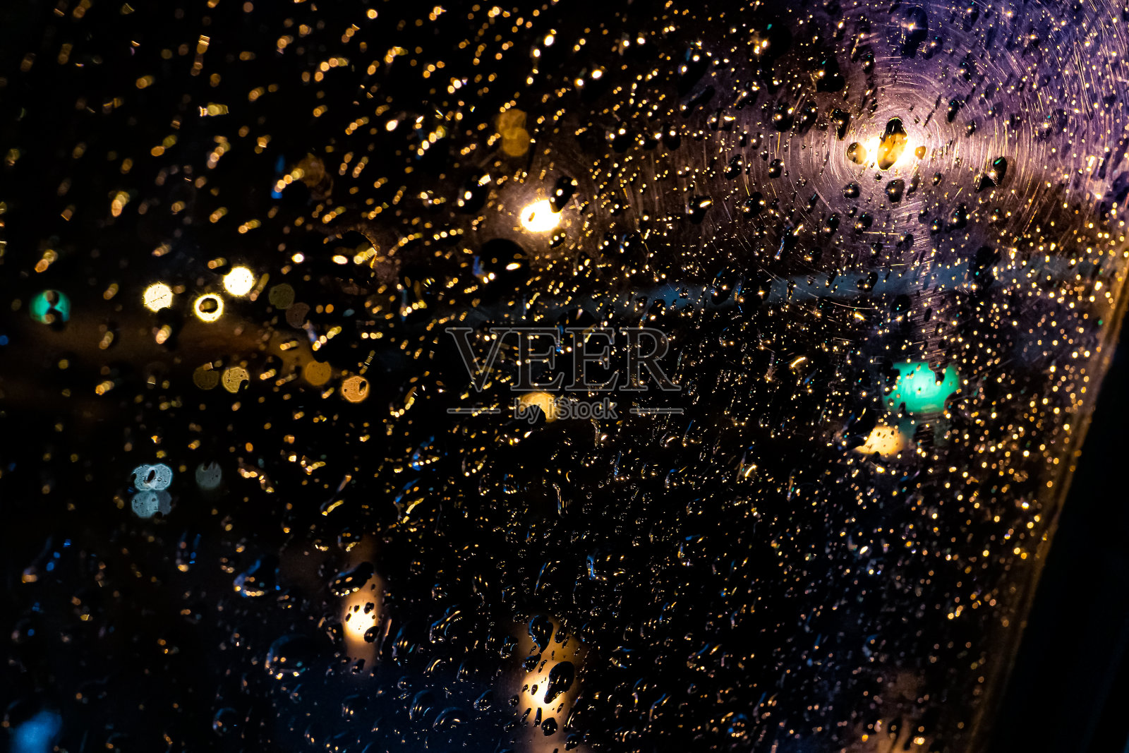 抽象的窗户雨点在黑暗的夜晚，夜景，彩色的机场透过飞机窗户与灯光和水照片摄影图片