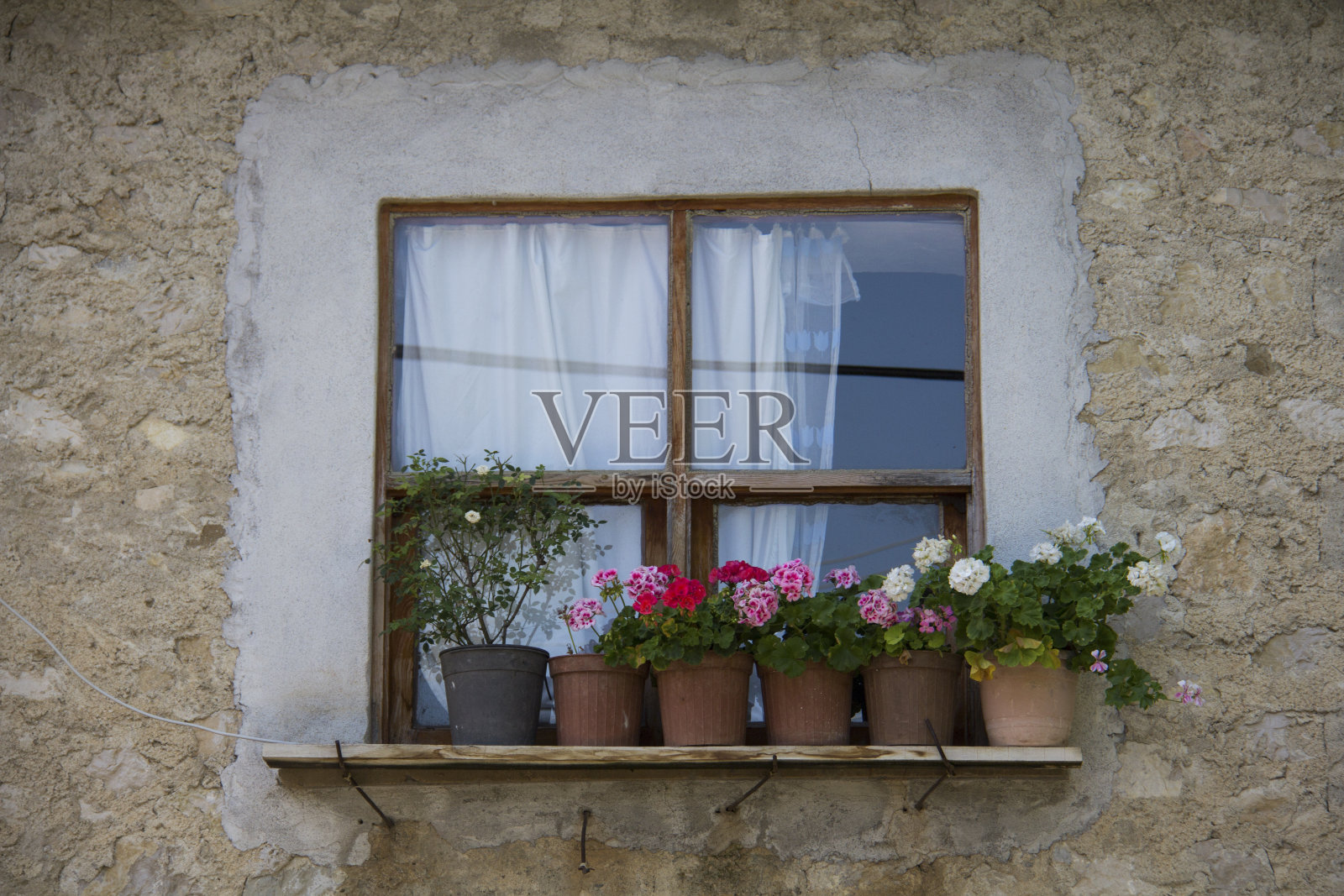 老房子前，窗户前的花盆里有五颜六色的花。照片摄影图片