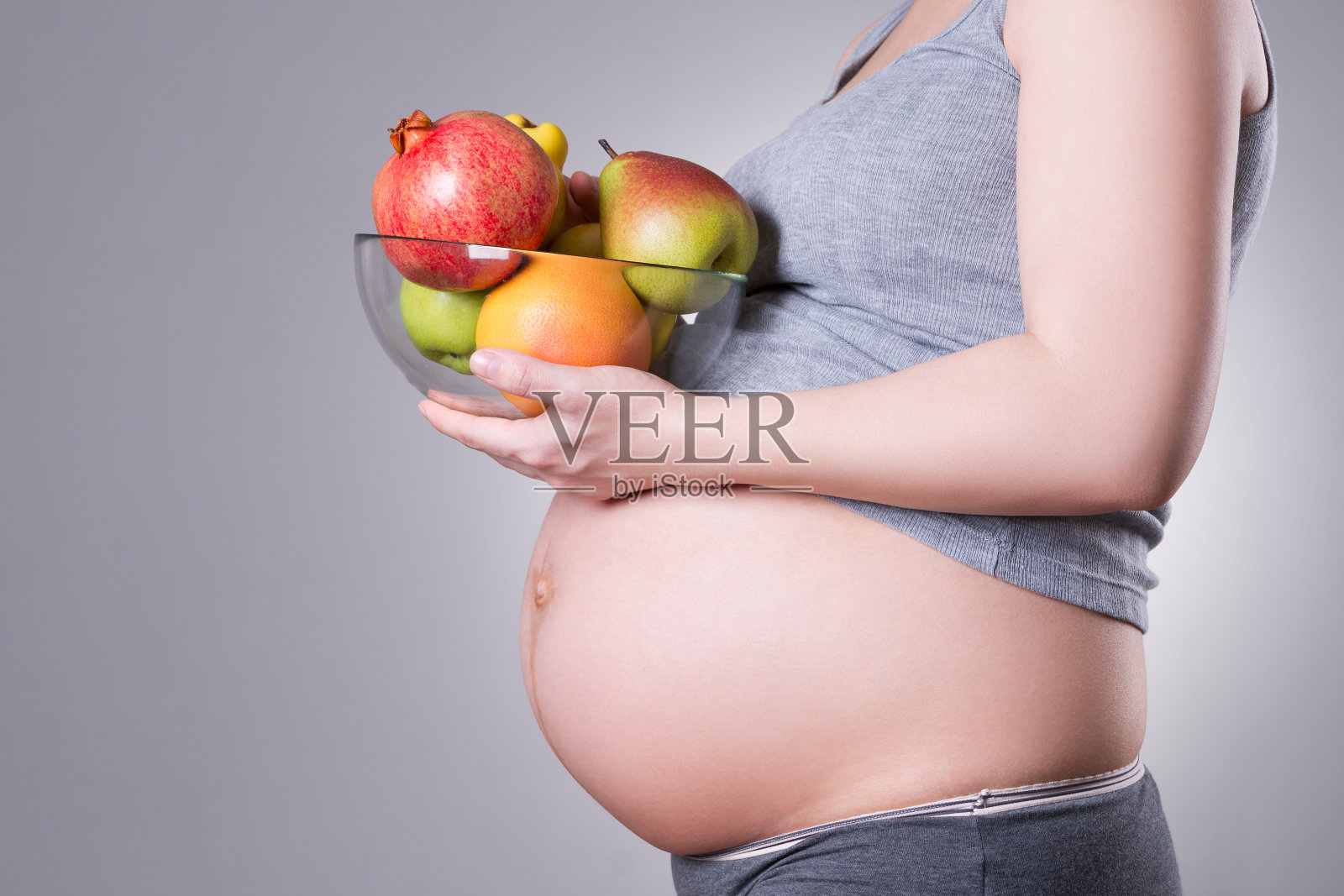 怀孕和营养-孕妇与新鲜水果的灰色背景照片摄影图片