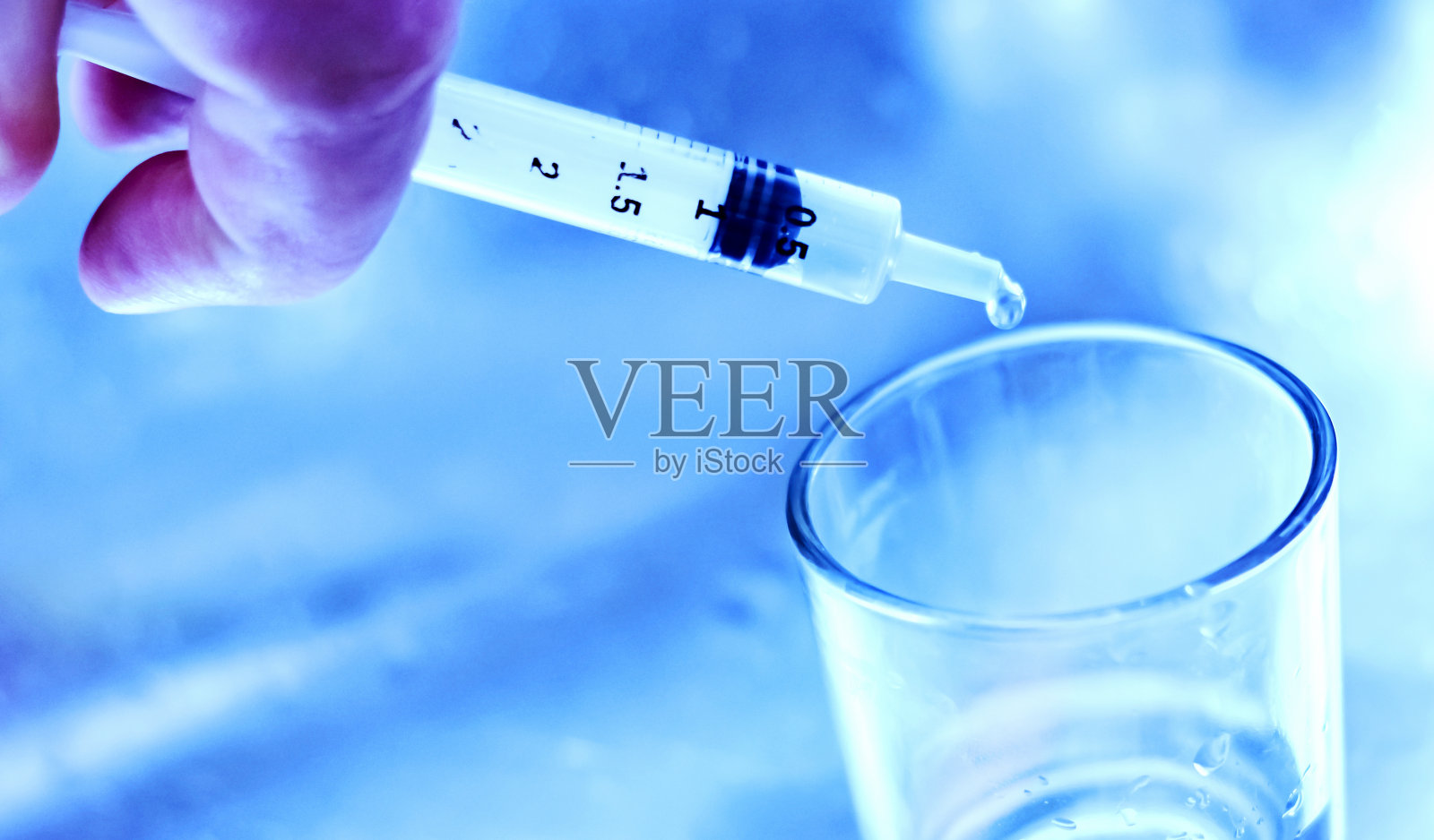 在科学分析和研究实验室，研究人员将小瓶中的液体倒入玻璃容器中寻找病毒疫苗。照片摄影图片