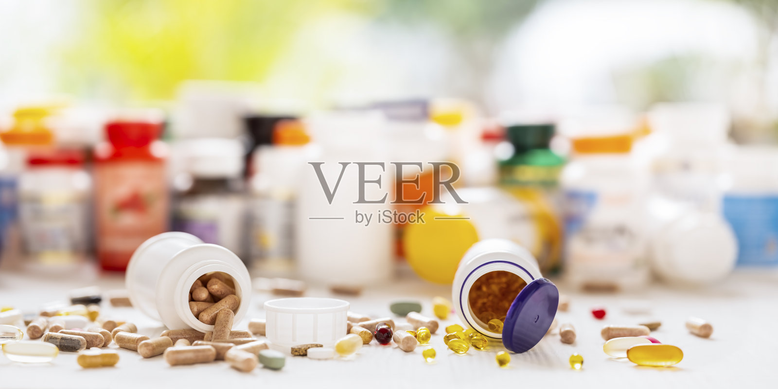 许多营养保健品和维生素都以胶囊、片剂为背景，以其药瓶为背景，聚焦深度较浅。照片摄影图片