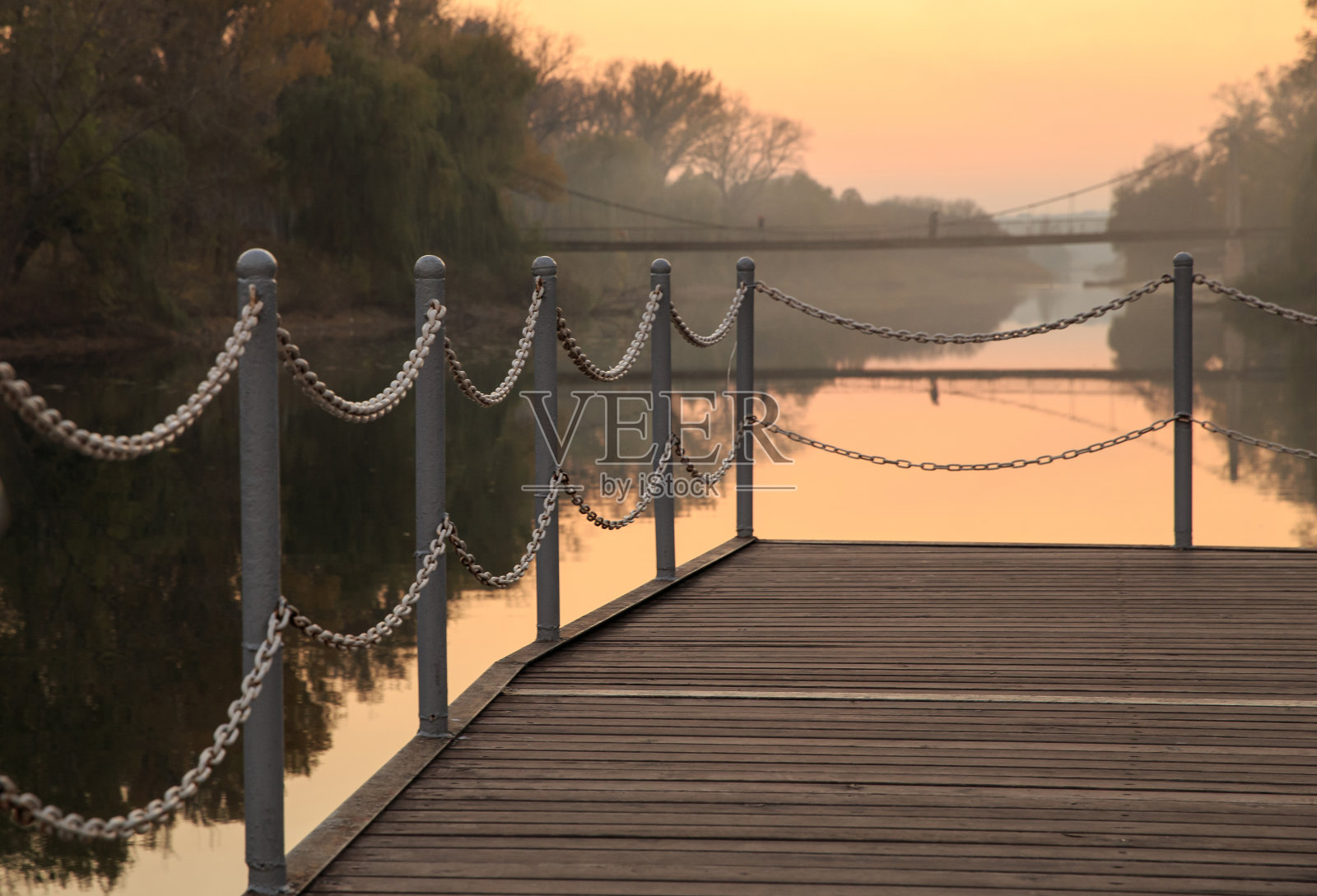 日落时河边的码头。链栅栏照片摄影图片