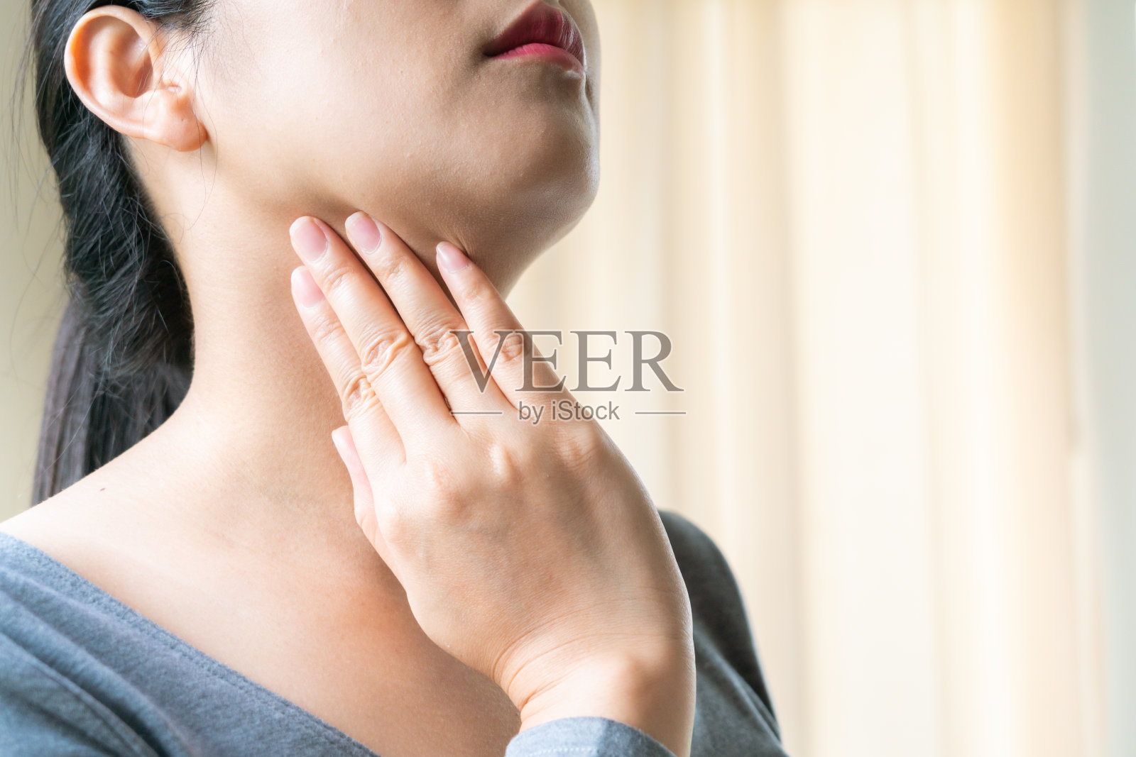 喉咙痛。漂亮女人的手抚摸着她疼痛的脖子。妇女保健概念照片摄影图片