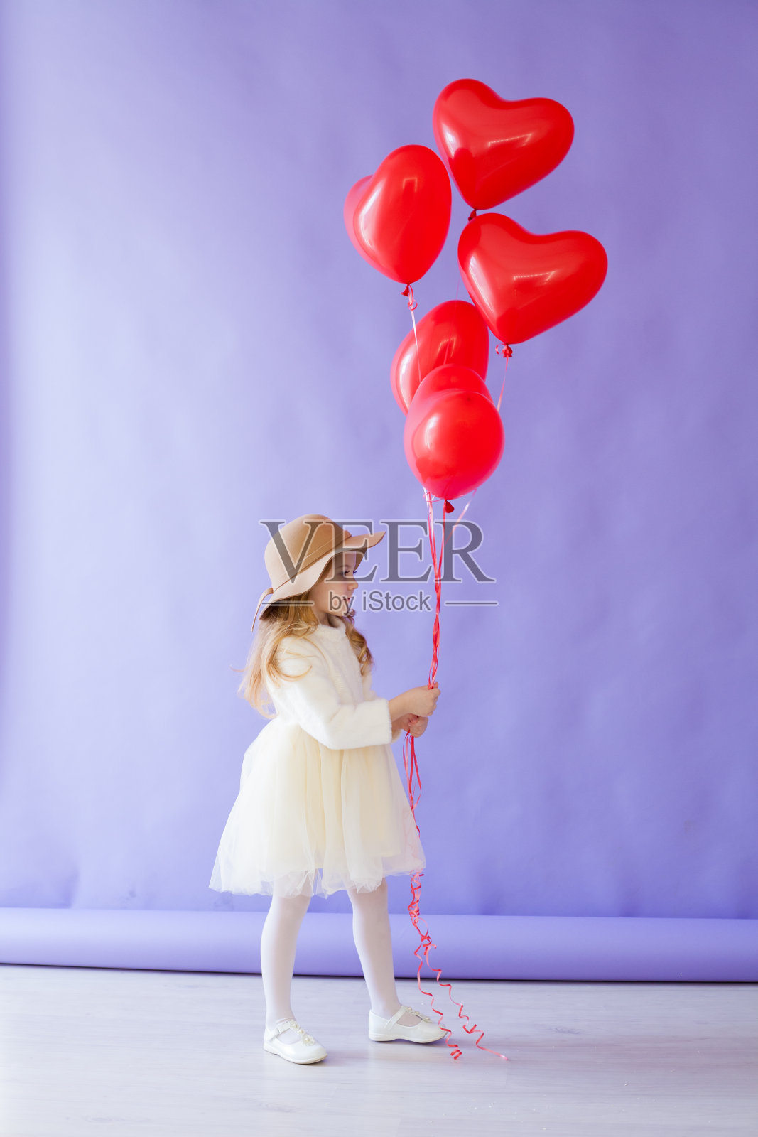小女孩拿着心形的红色气球照片摄影图片