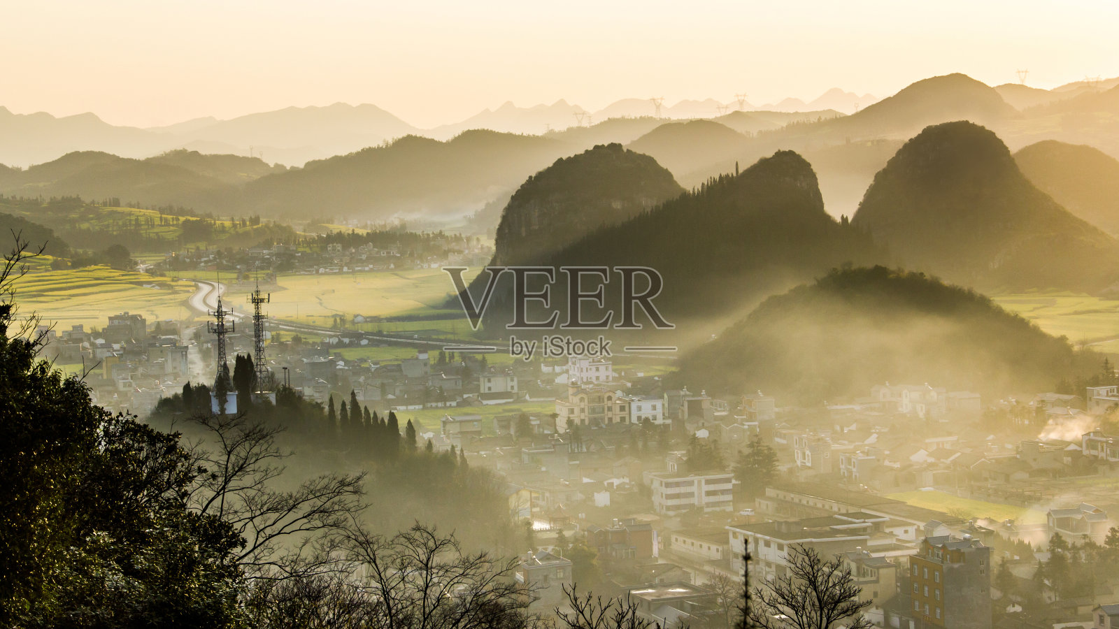 中国云南，一个春天的早晨，雾气弥漫的村庄和山脉照片摄影图片