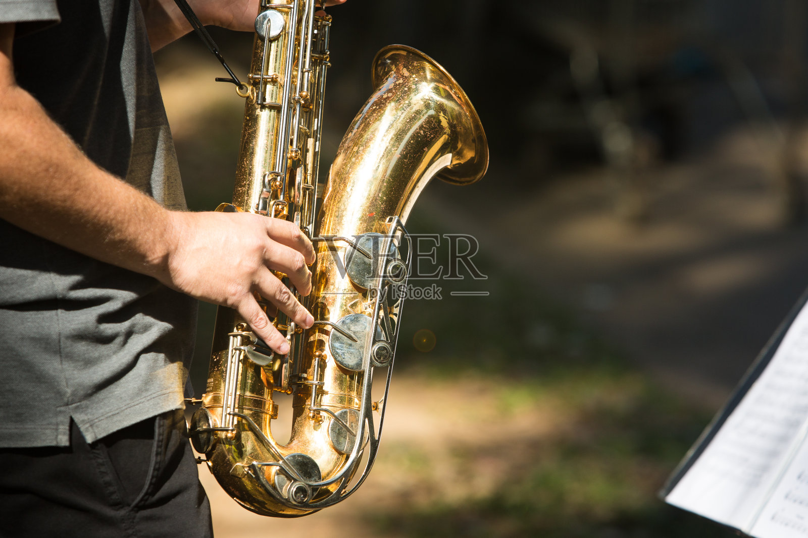 在阳光明媚的日子里吹萨克斯风的街头音乐家照片摄影图片
