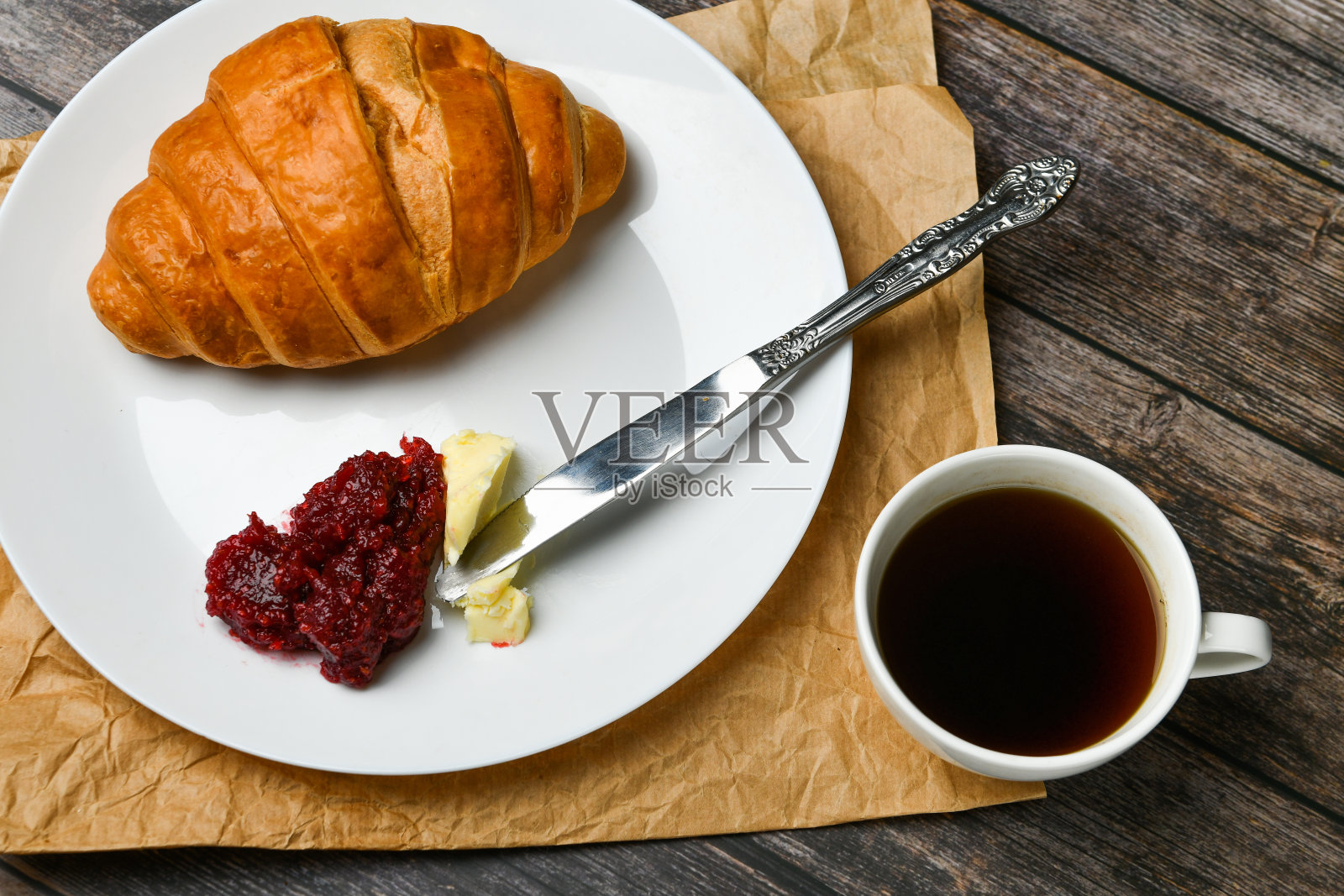 早餐,羊角面包。清晨的开始。新的法国羊角面包。木质背景上放着咖啡杯和新鲜烘焙的羊角面包。从以上观点。早餐有羊角面包和咖啡照片摄影图片