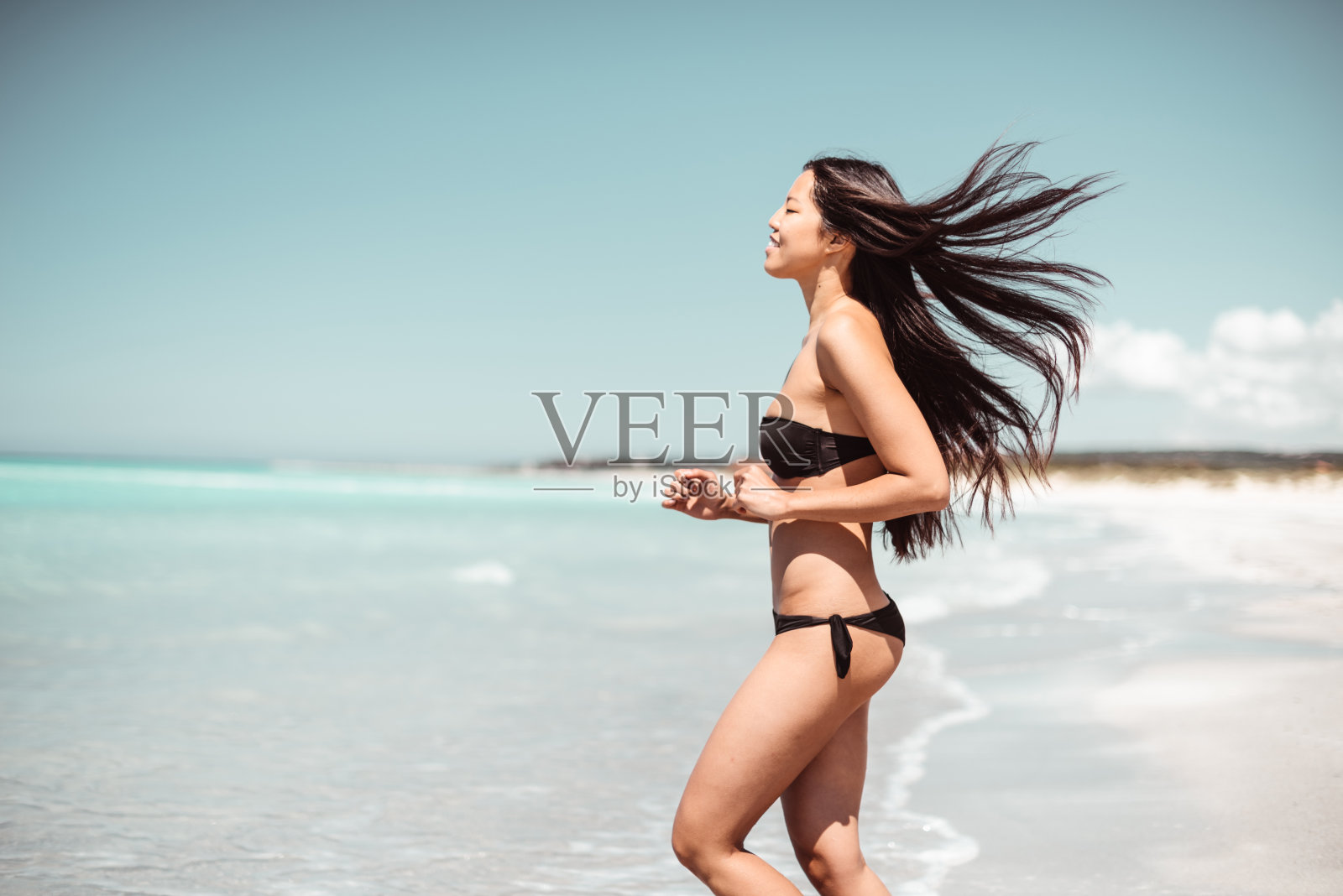在海滩上跑步的女人照片摄影图片