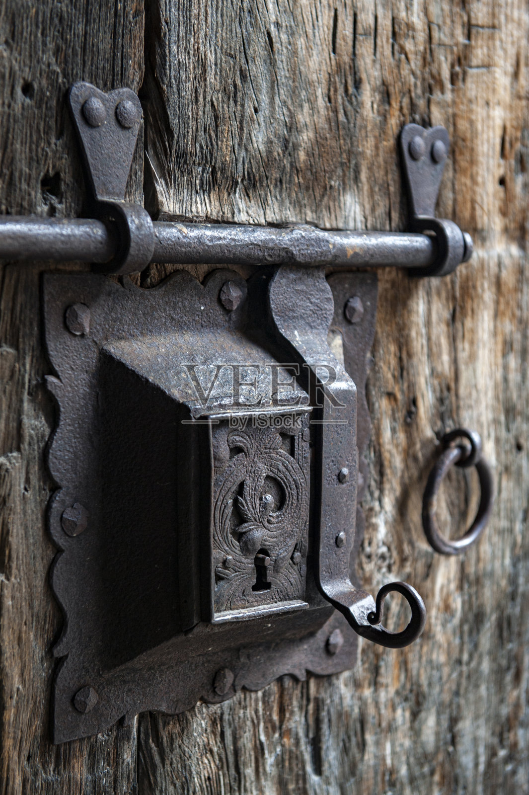 一种古老的生锈钢锁螺栓，安装在中世纪的旧木门上，有一个钥匙孔照片摄影图片