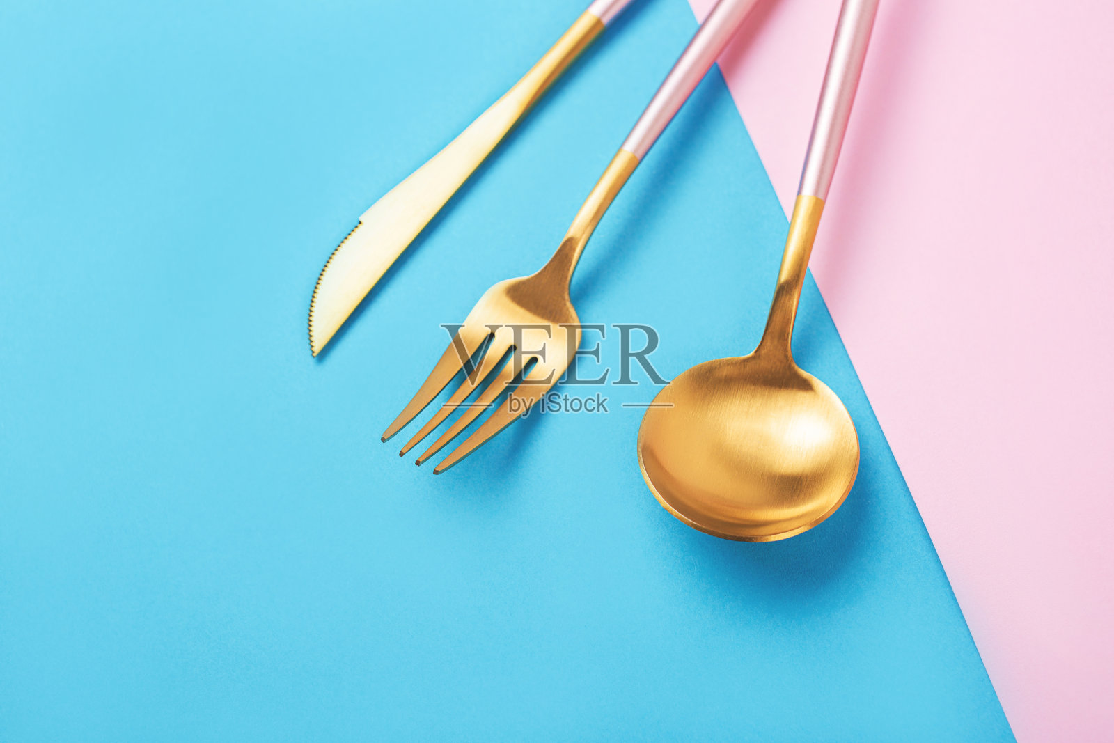 美丽的餐具设置在粉红色和蓝色的背景。照片摄影图片