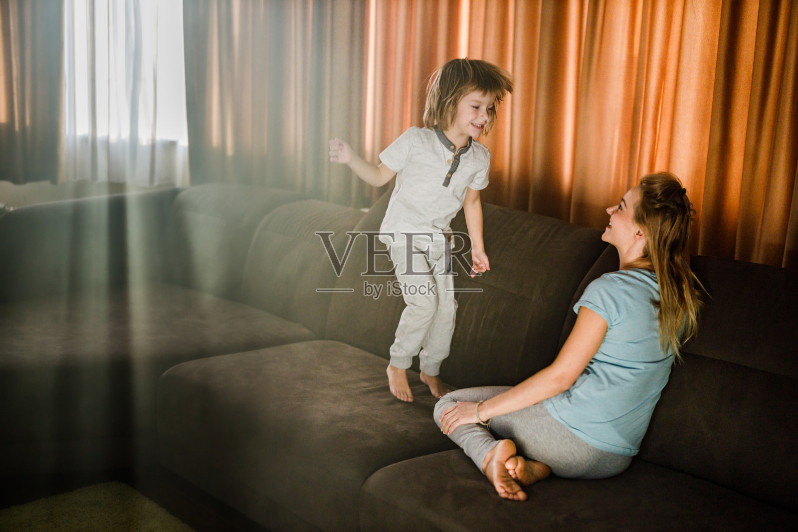 快乐男孩在家里和他的单身妈妈聊天。照片摄影图片