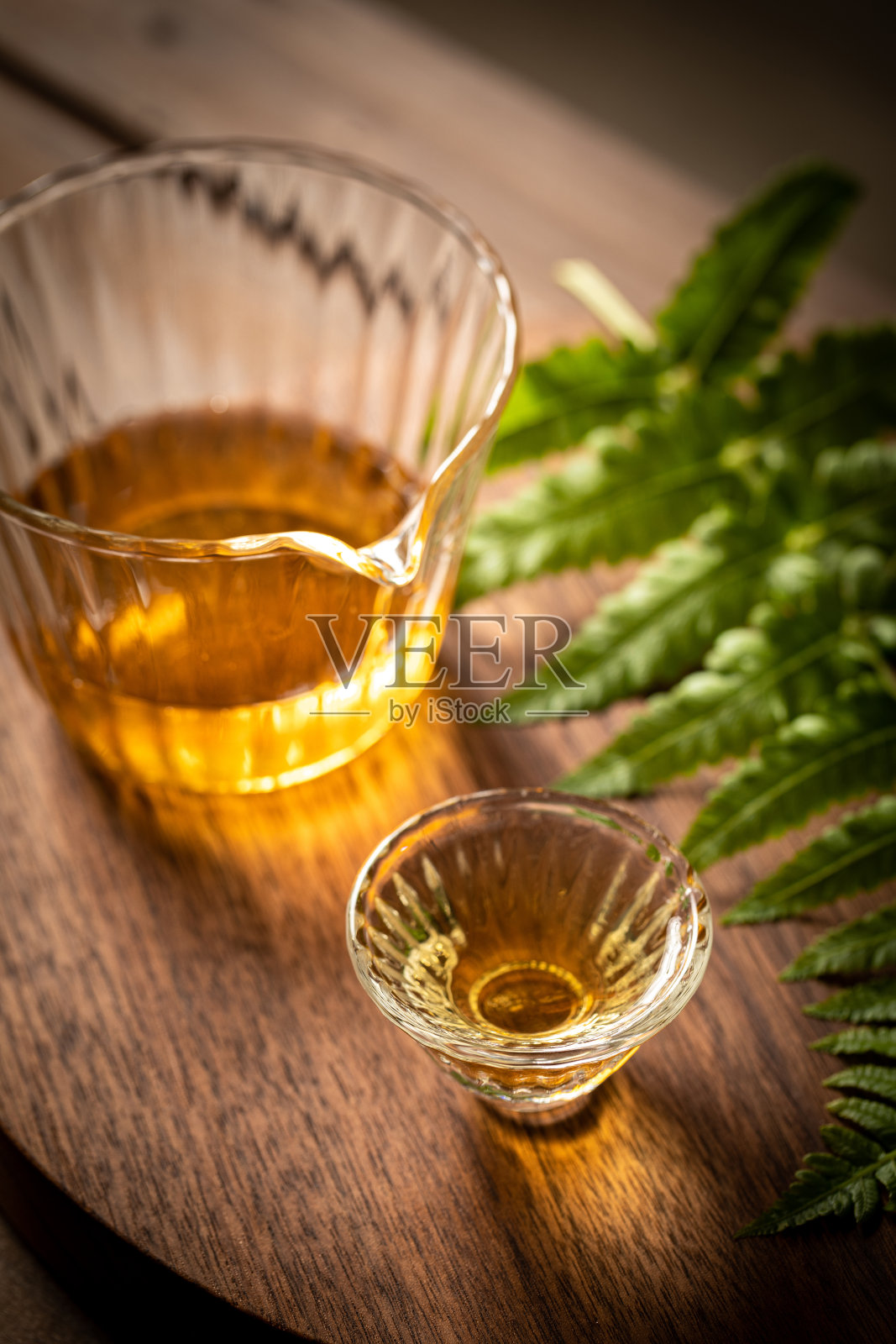 茶和蕨叶放在胡桃木托盘上。照片摄影图片