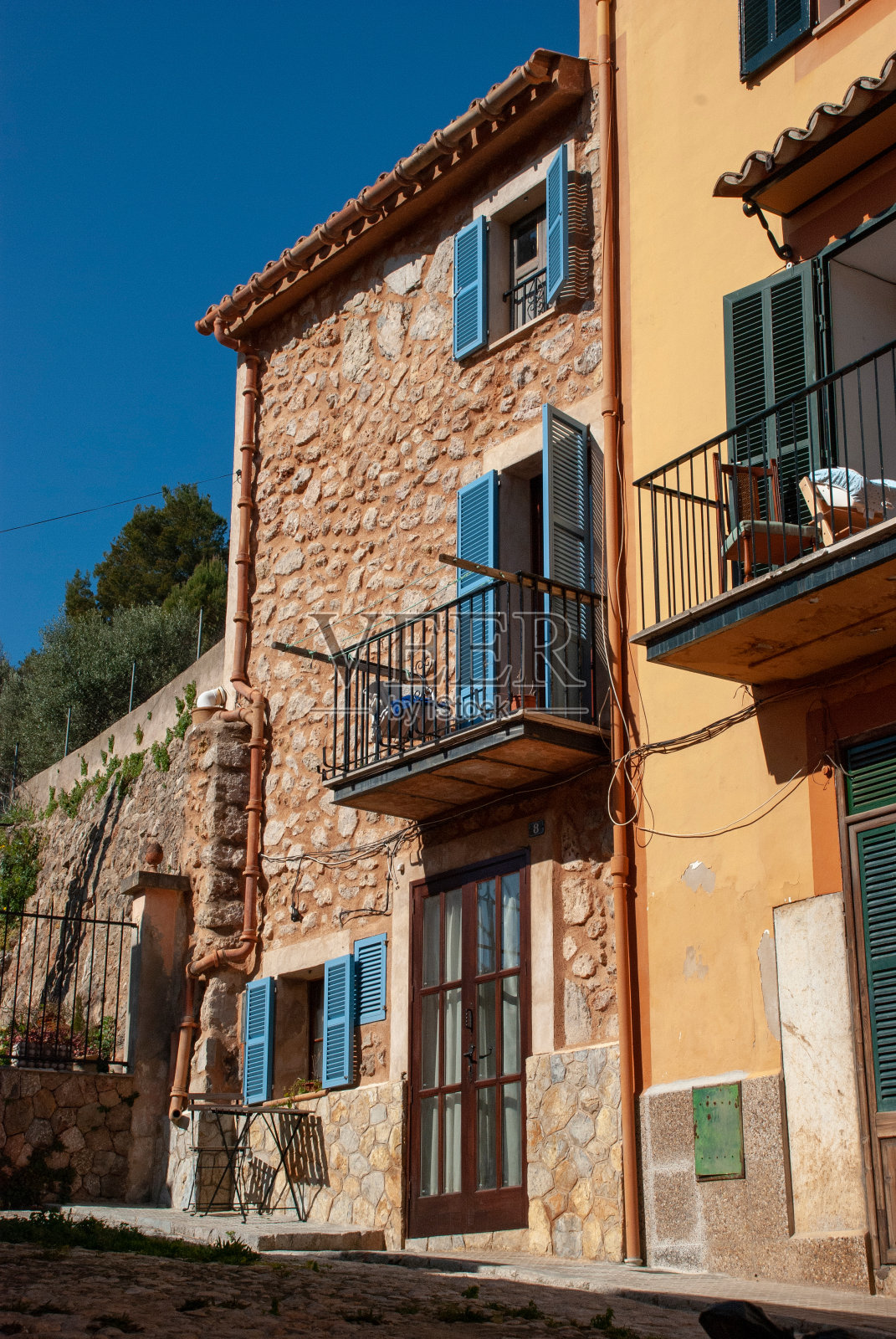 地中海式建筑——西班牙马略卡岛的石屋，五颜六色的百叶窗和阳台照片摄影图片