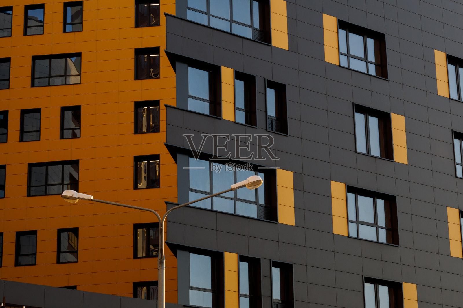 带有窗户的黄褐色现代通风立面。一个新的精英住宅或商业综合体的碎片。照片摄影图片