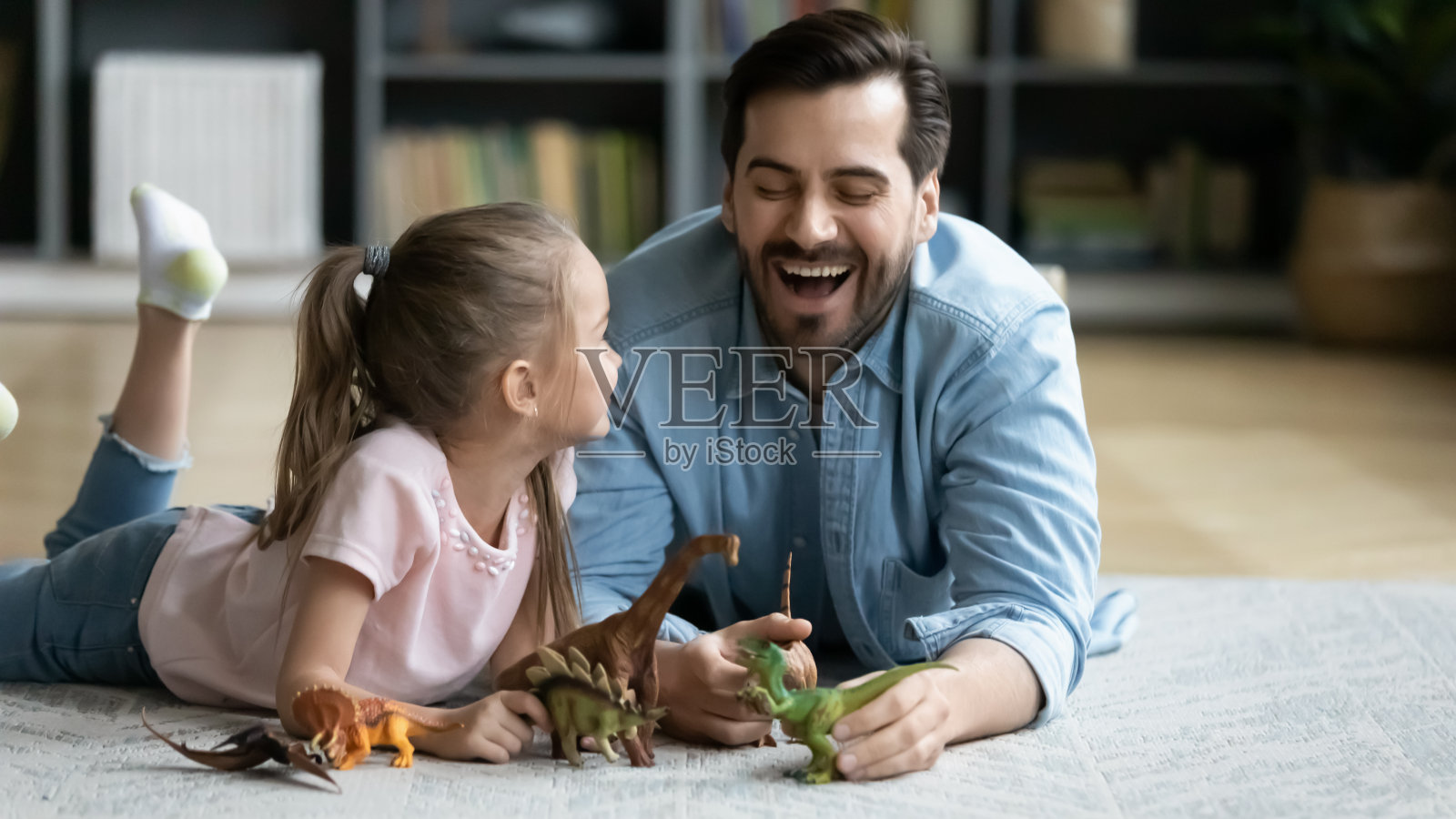 爸爸和小女儿玩恐龙玩具玩得很开心照片摄影图片