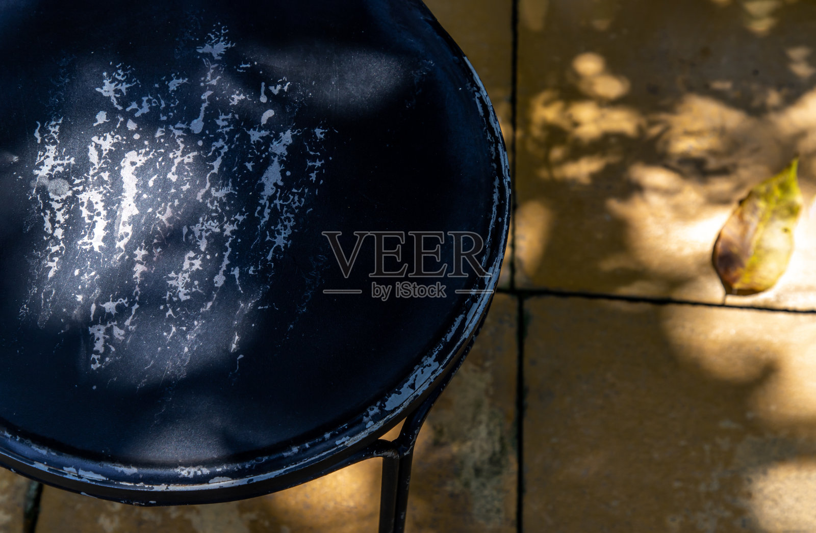 阳光照在后院的黑钢椅子上。照片摄影图片