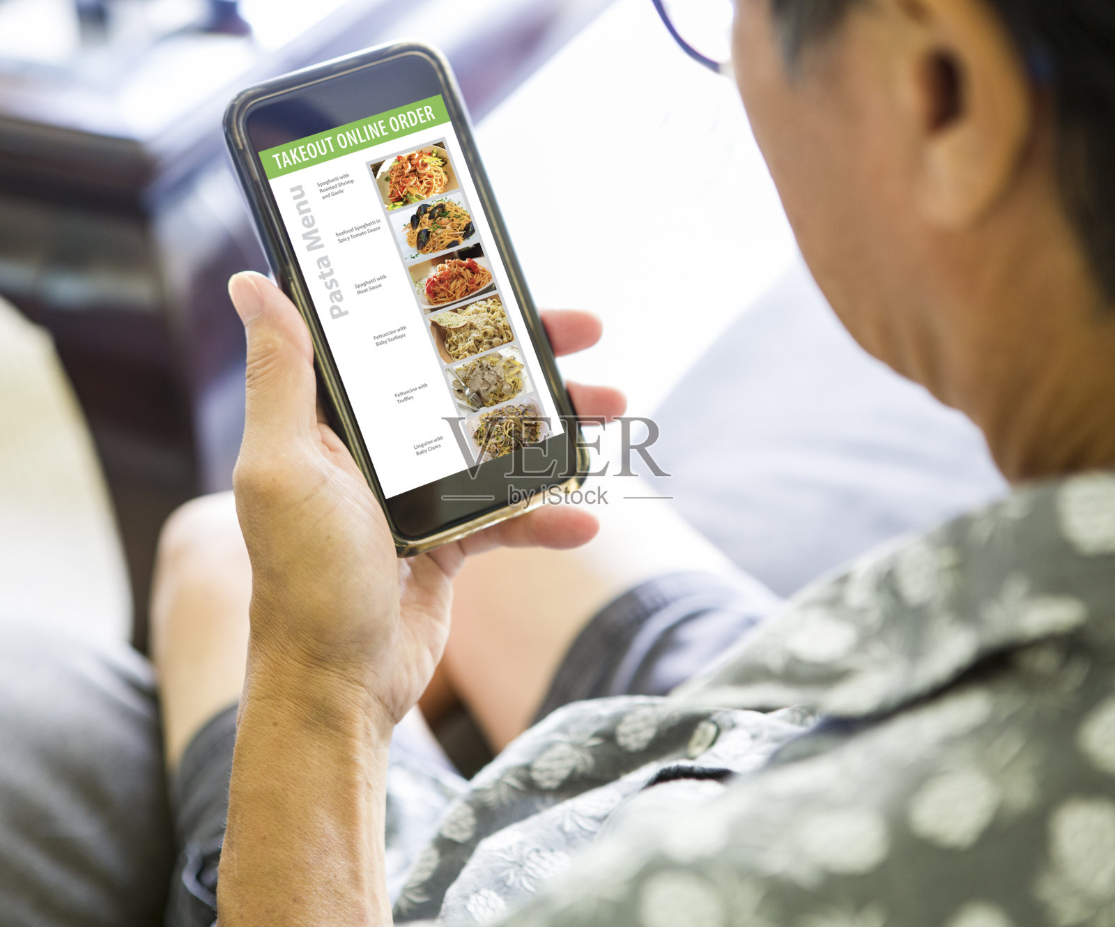 2019冠状病毒病的就地避难所和社交距离，用智能手机在线订购外卖、配送便利食品照片摄影图片