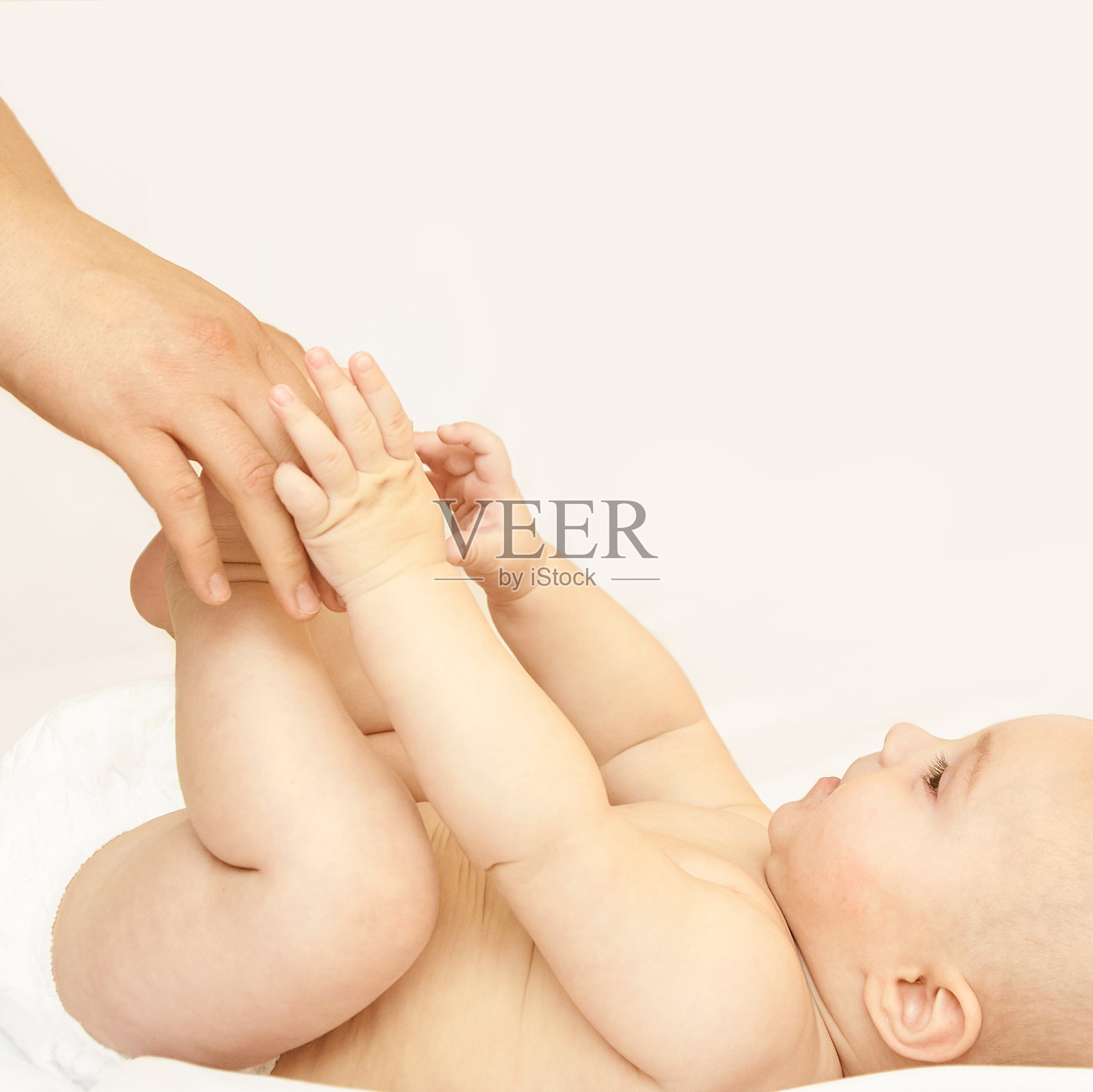 新生儿，母亲的手。婴儿妈妈按摩。有趣的孩子换尿布。首页照片摄影图片