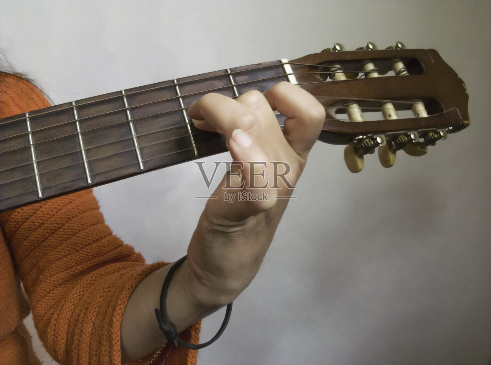 女子弹奏原声吉他，手是可见的特写照片摄影图片