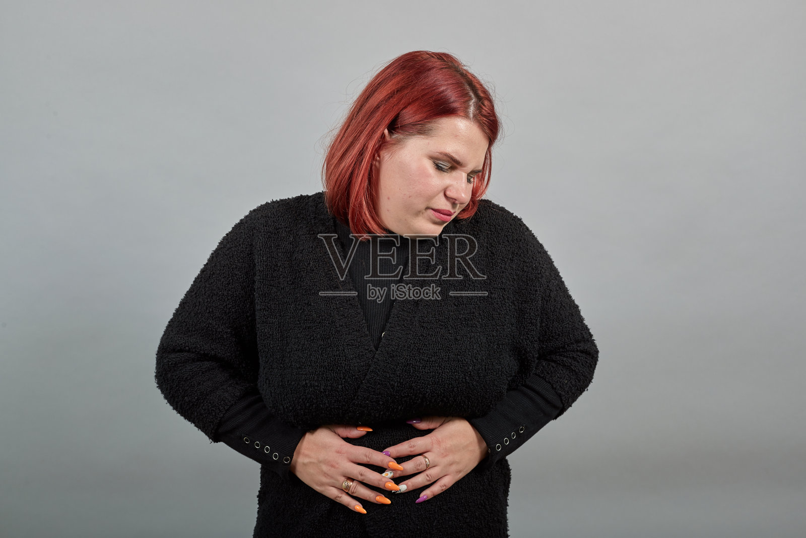 穿着黑毛衣的胖女人穷困的女人肚子疼，肚子疼照片摄影图片