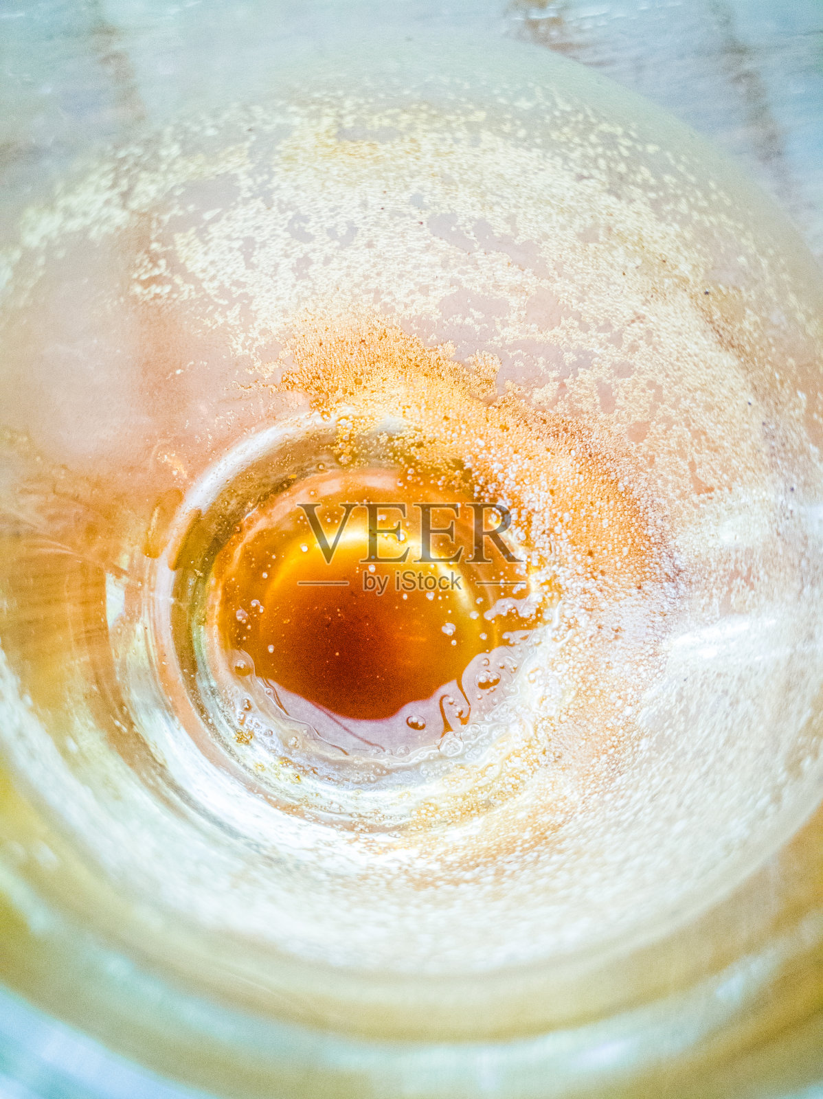 淡褐色的咖啡渍，木头上玻璃杯里的白色气泡。照片摄影图片
