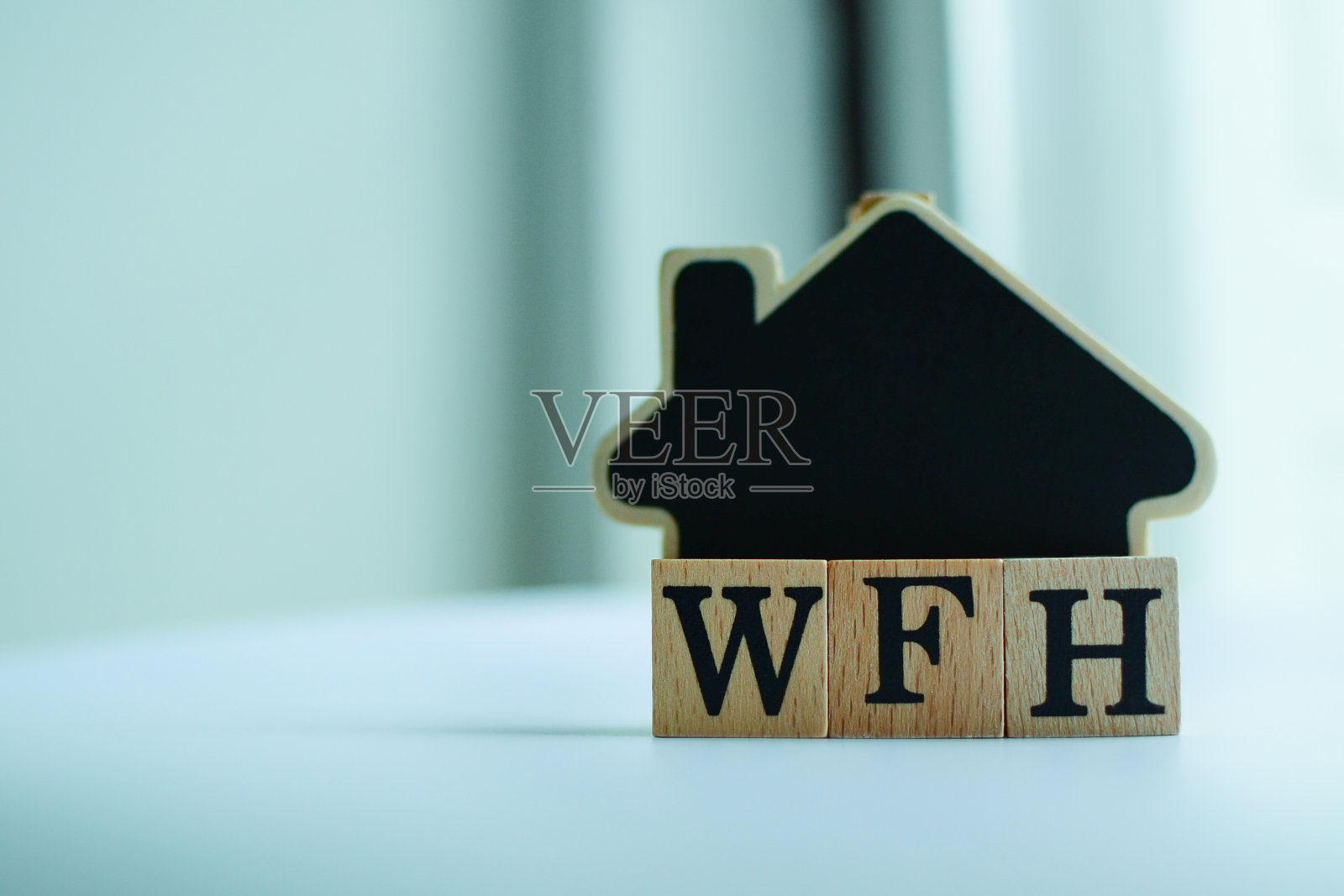 WFH木块(代表在家工作)和房屋模型。照片摄影图片