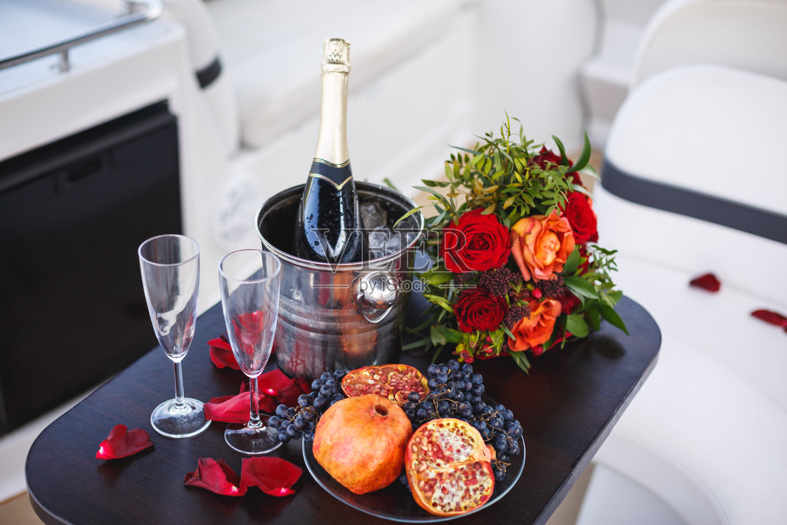 在航行中与凉爽的香槟和水果。户外浪漫晚餐。照片摄影图片