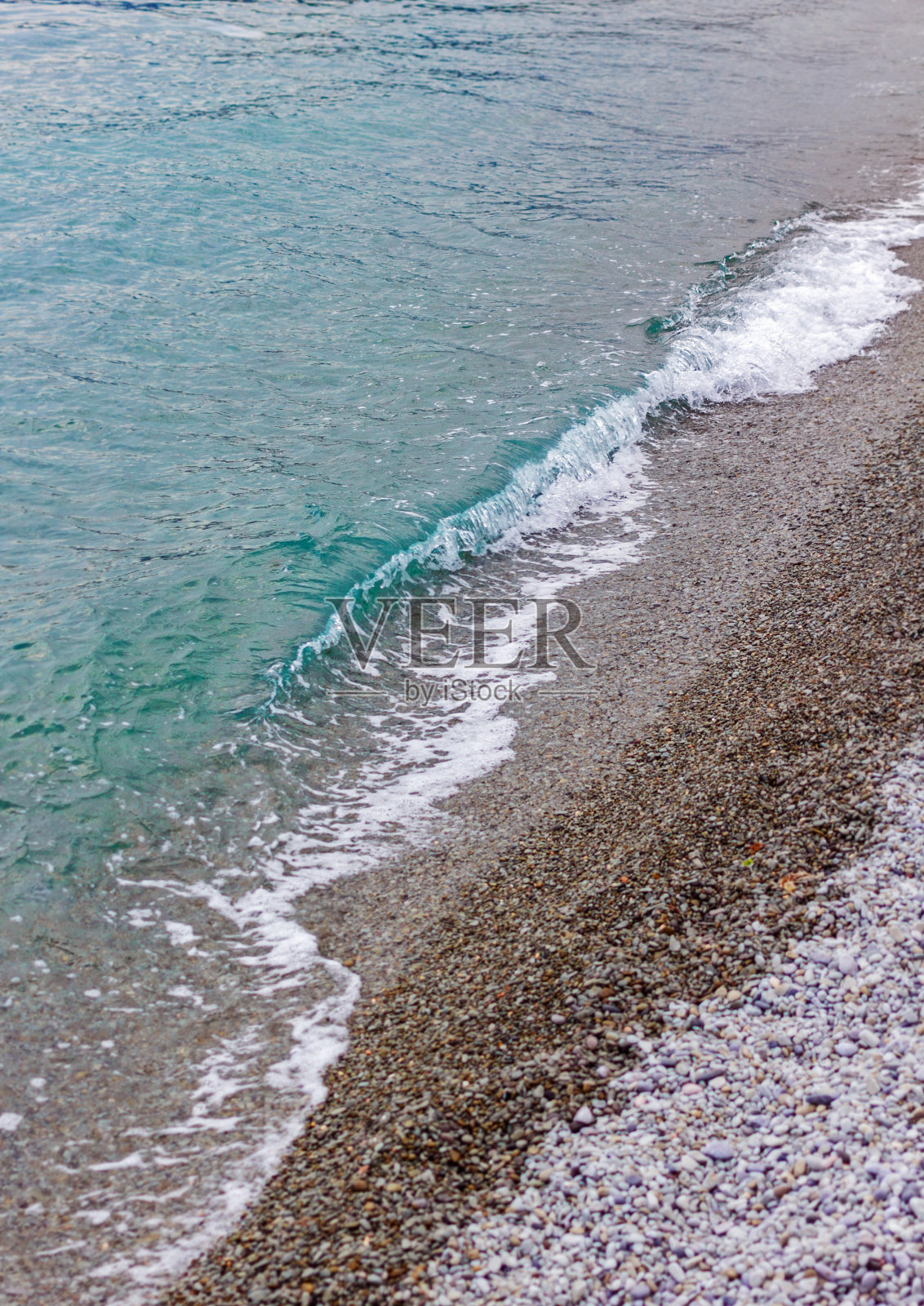 平静的海浪拍打着沙滩上的卵石照片摄影图片