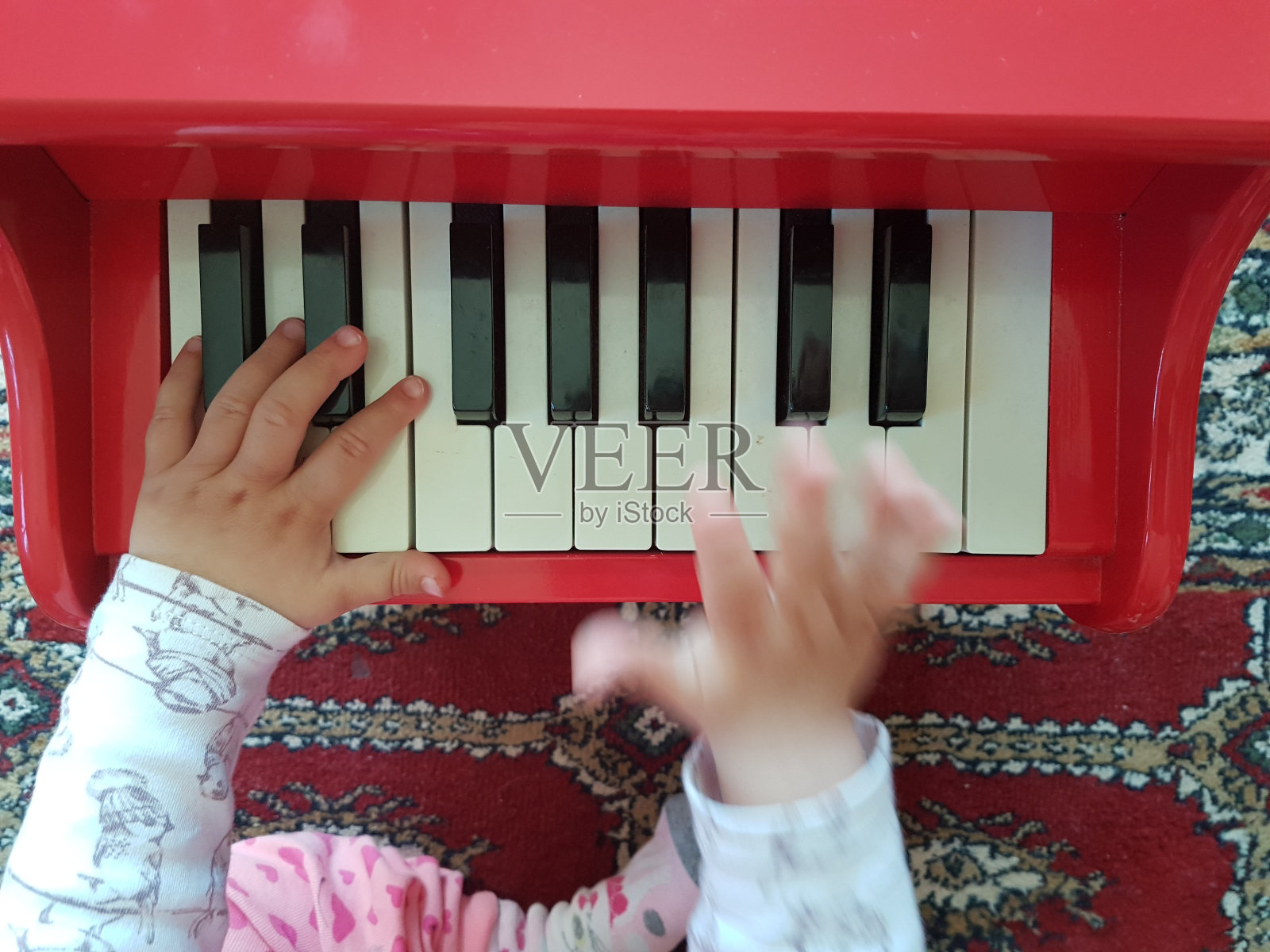 钢琴宝宝俯视图，双手弹奏红色钢琴照片摄影图片