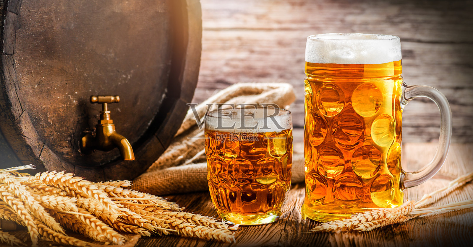 啤酒杯和古老的啤酒桶小麦，啤酒靠近椒盐卷饼在酒窖的木桌照片摄影图片