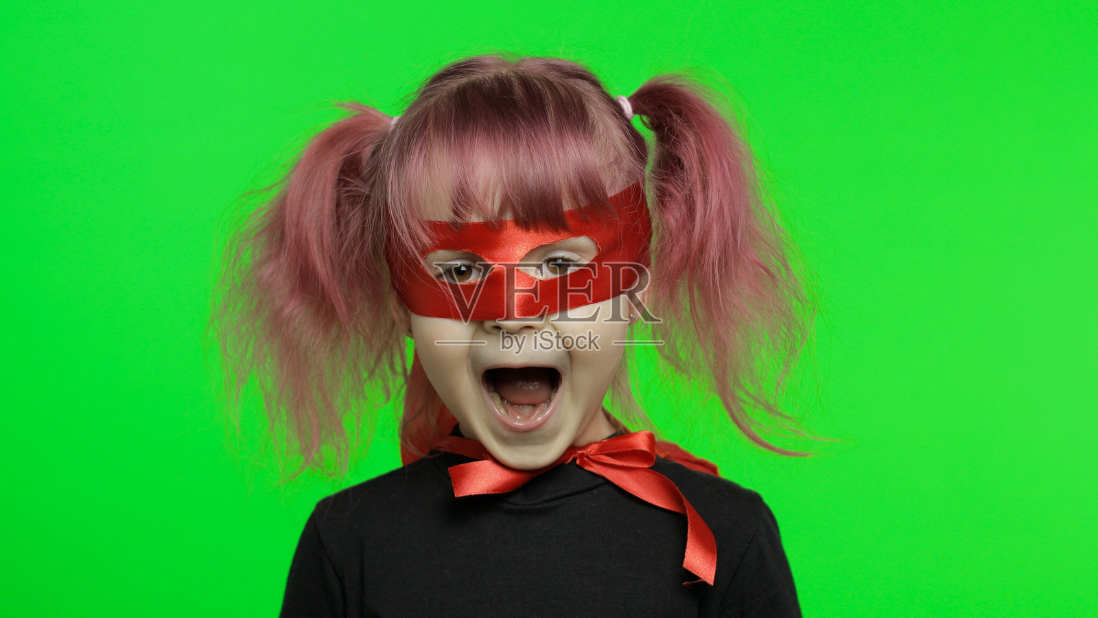 滑稽的小女孩穿着服装和面具扮演超级英雄。国家英雄日照片摄影图片
