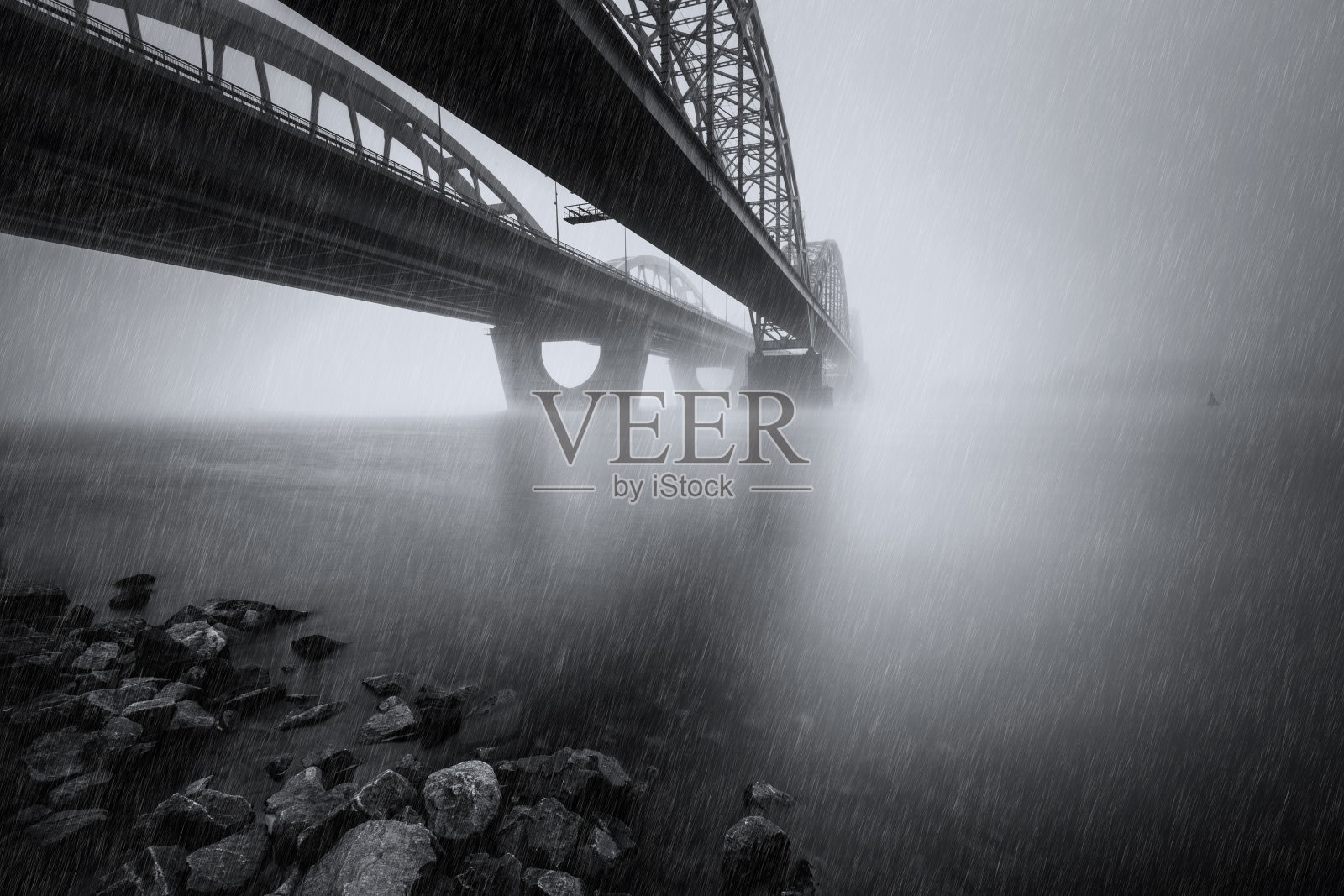 两座平行的桥在雾河上，在雨中。长时间曝光拍摄。照片摄影图片