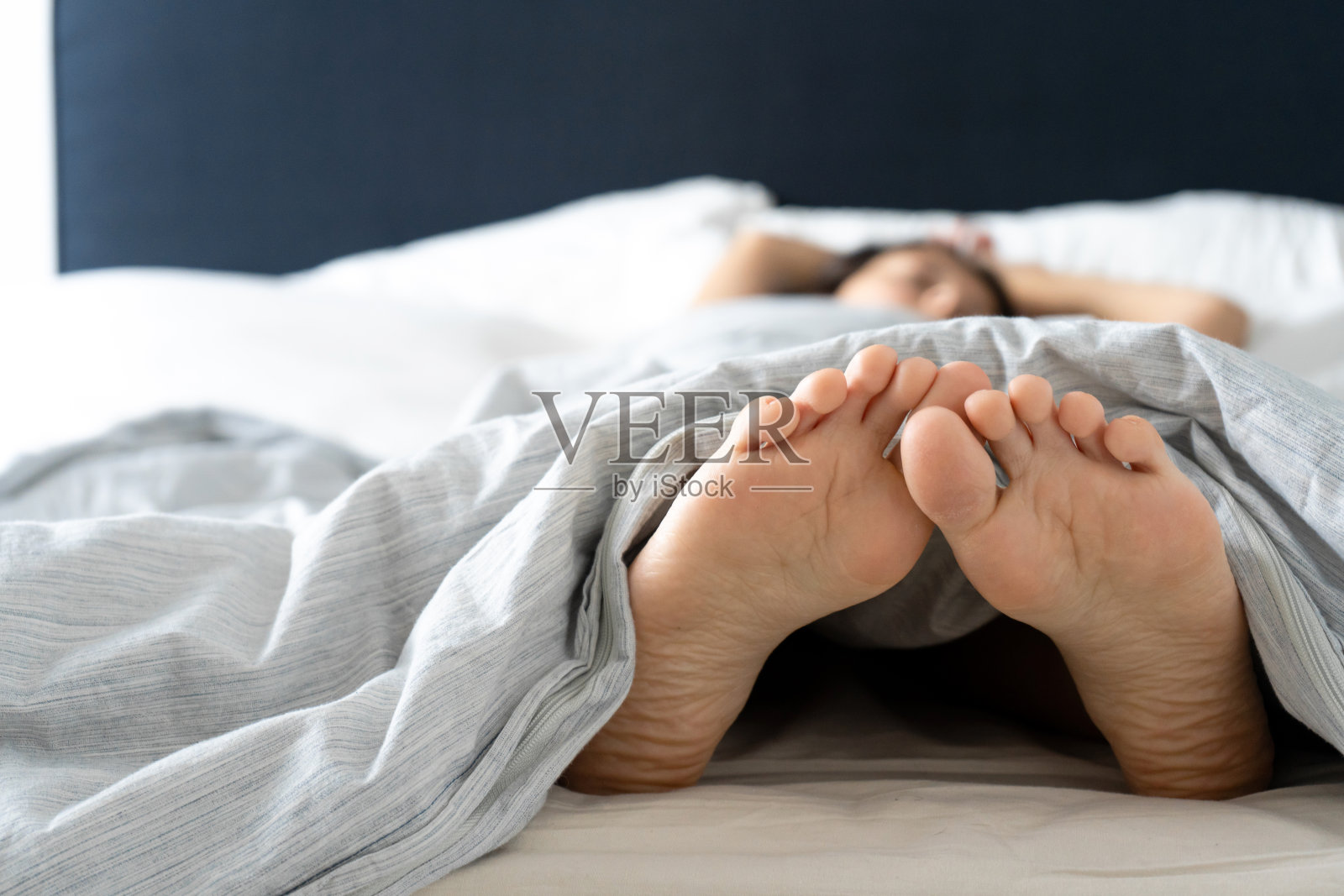 早上睡觉的女孩的脚。间谍照片。照片摄影图片