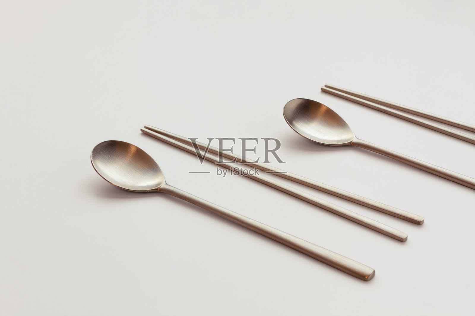 韩国高质量的黄铜餐具。勺子和筷子孤立在白色背景上。照片摄影图片