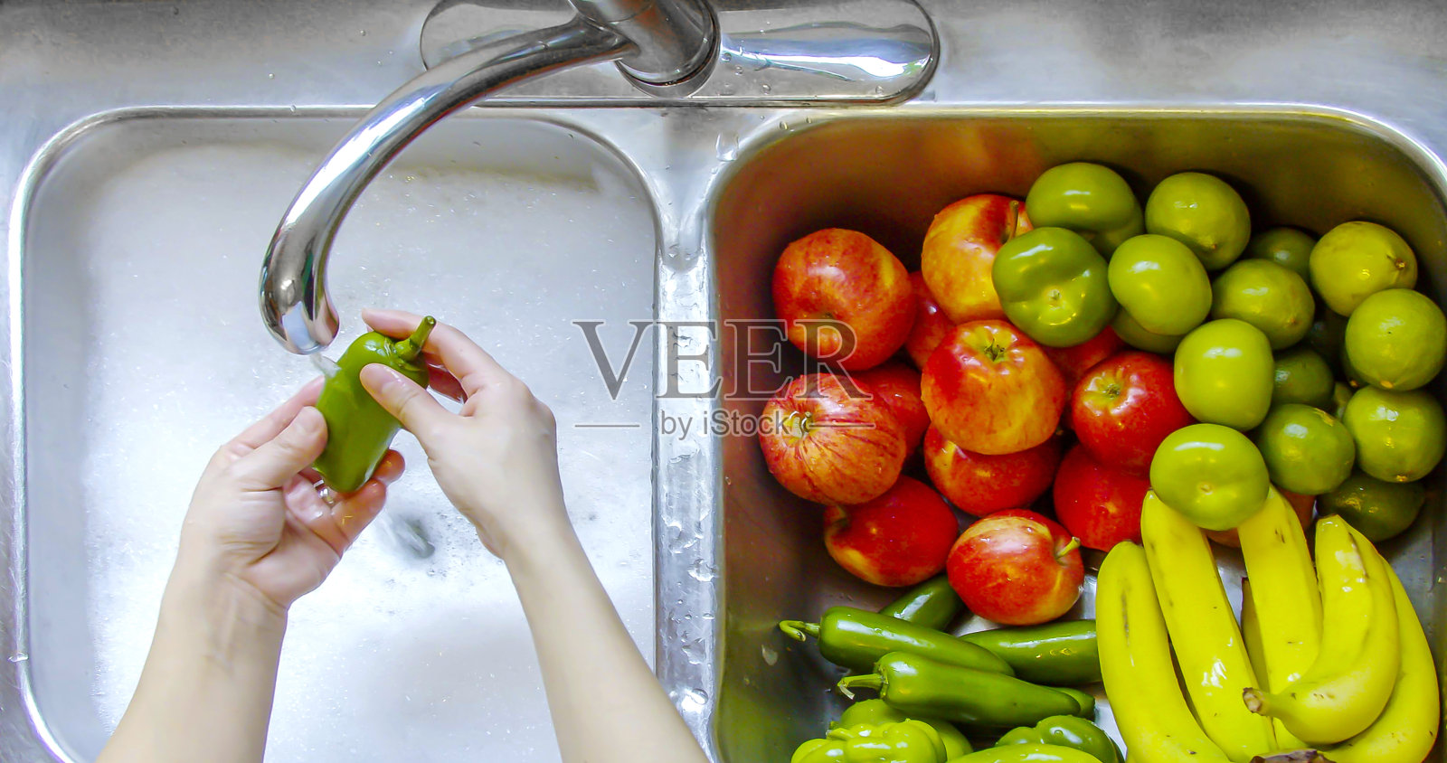 用流动的水和肥皂洗蔬菜和水果的人照片摄影图片