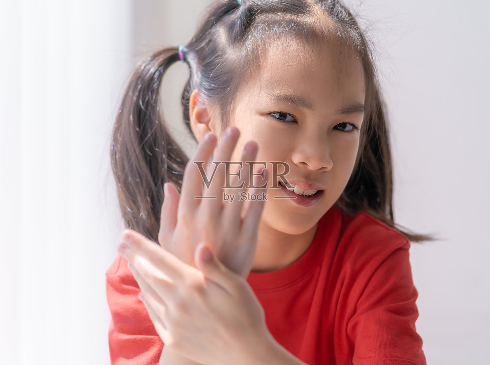 小女孩正在涂抹护手霜和洗手液，以保护皮肤。照片摄影图片