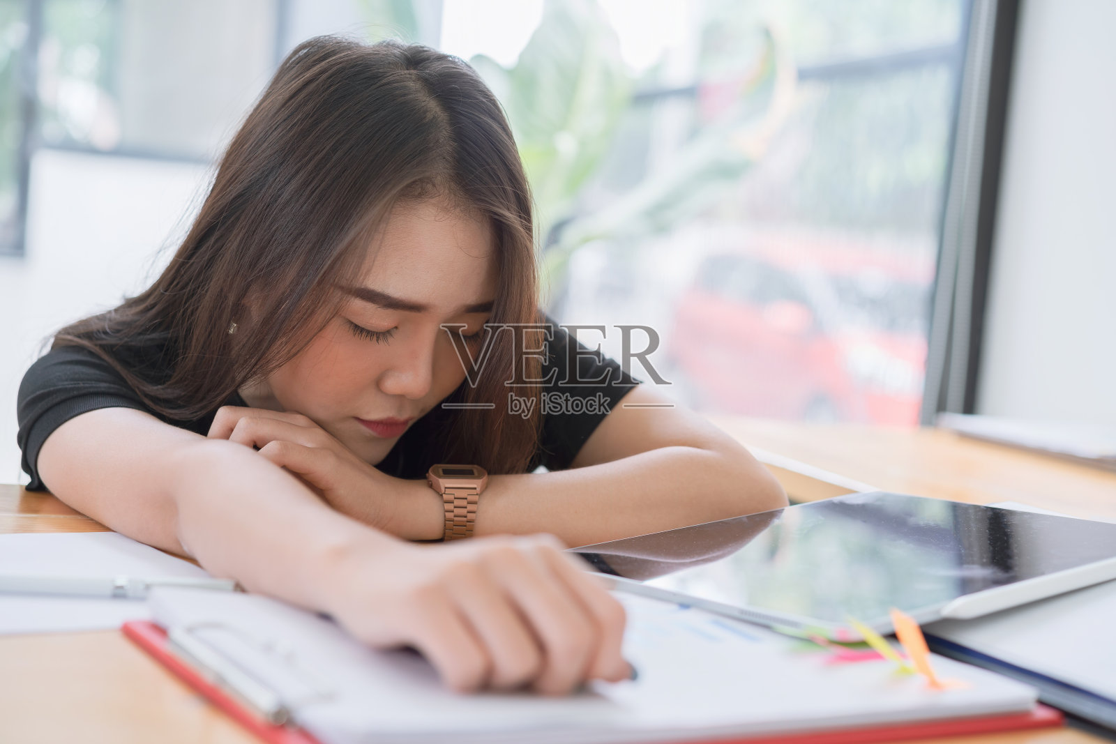 一个疲惫的女办公室工作人员坐着，在努力工作后睡着了。照片摄影图片