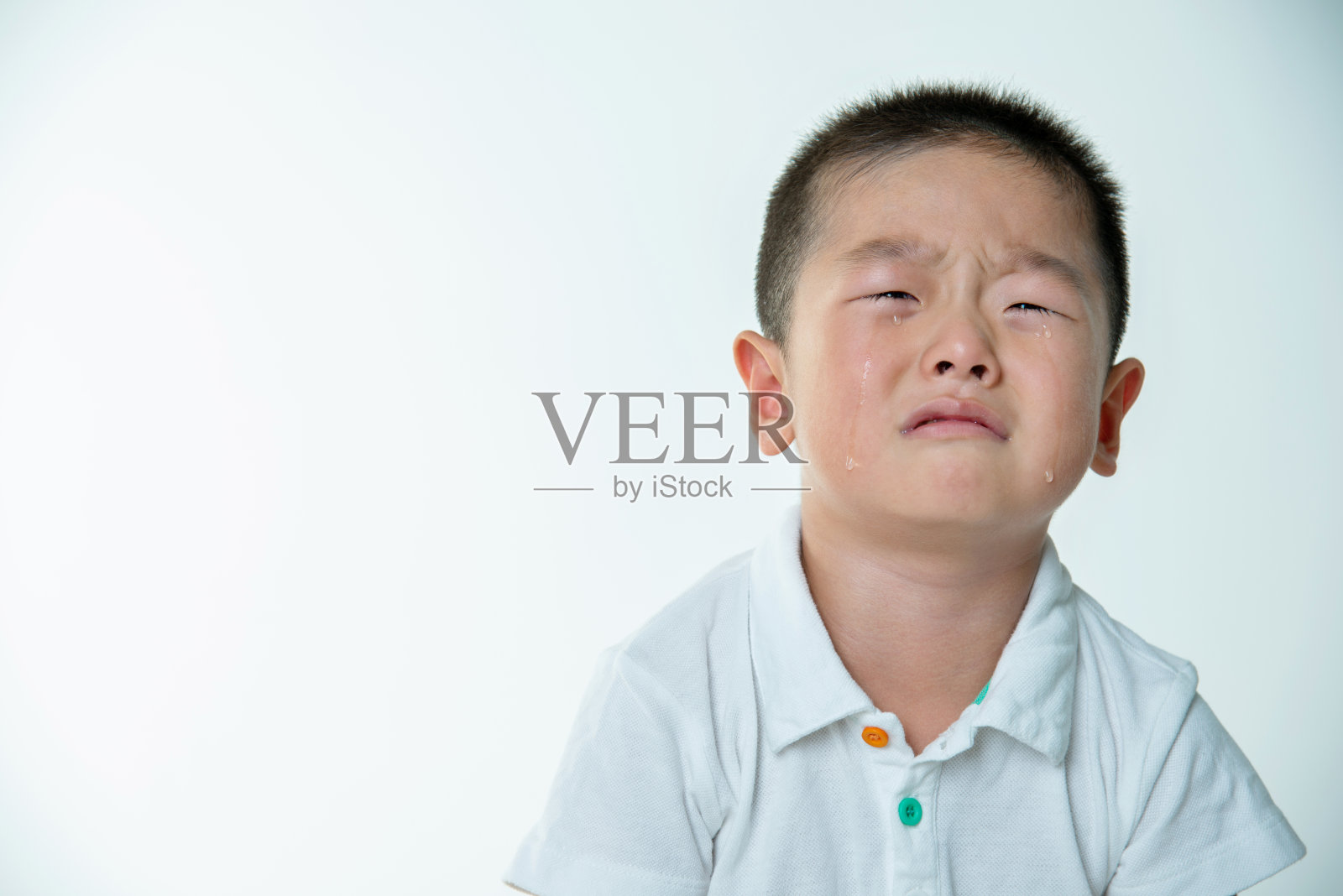一个亚洲男孩在白人背景下哭泣照片摄影图片