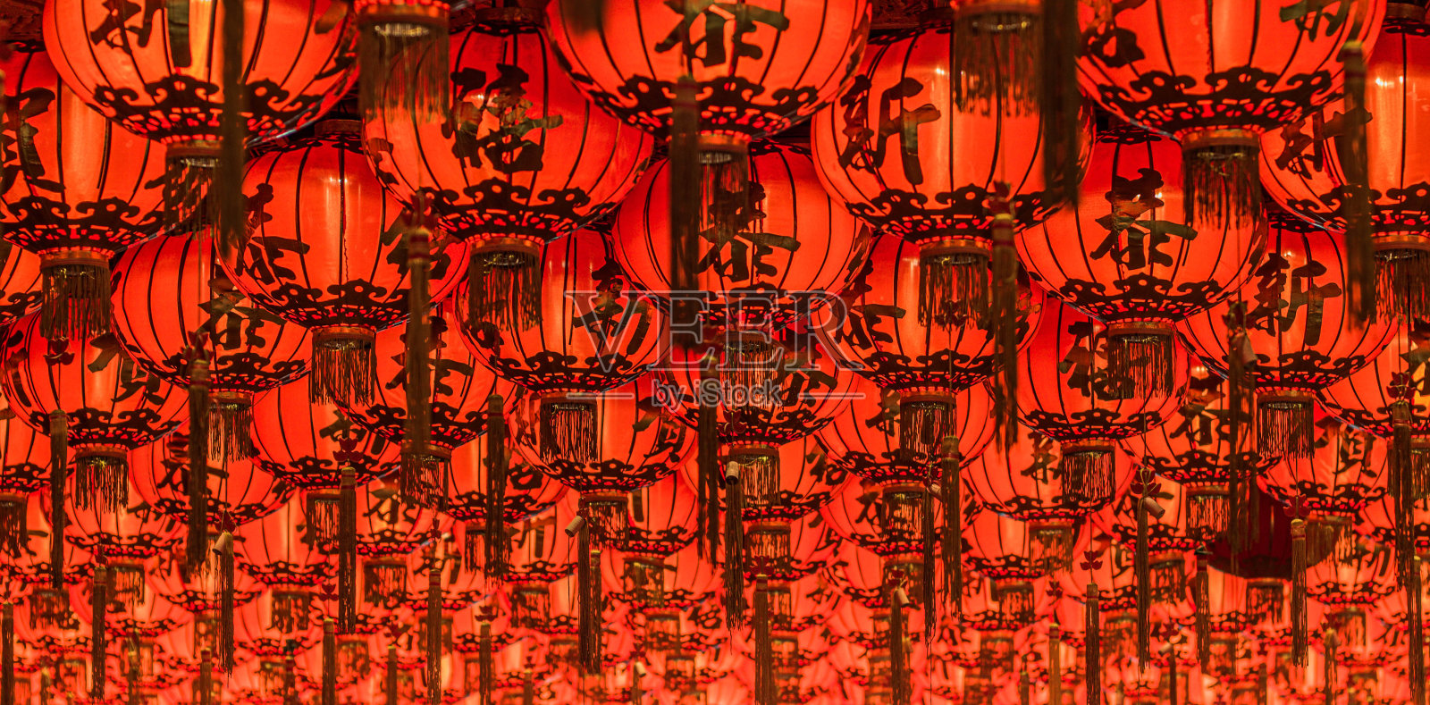 中国的红灯笼在晚上挂在街上装饰。中文字母写的意思是好运。照片摄影图片