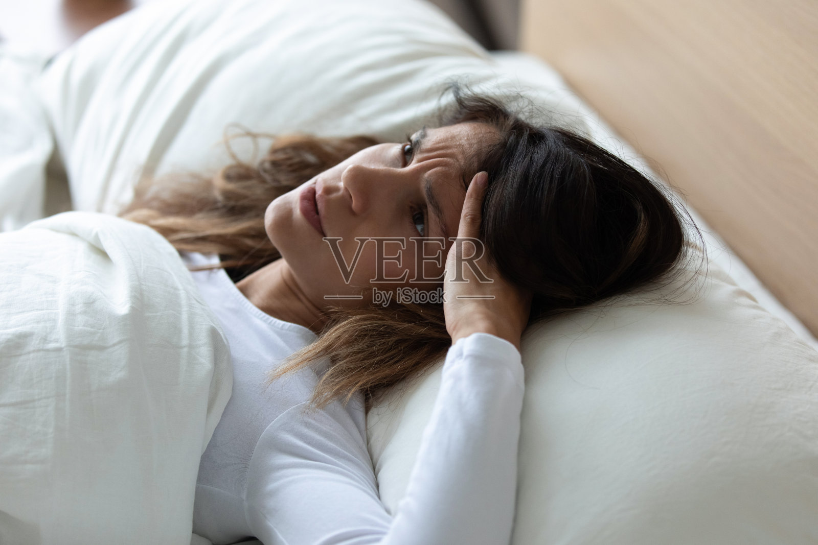 近距离看不开心的女人失眠，躺在床上照片摄影图片