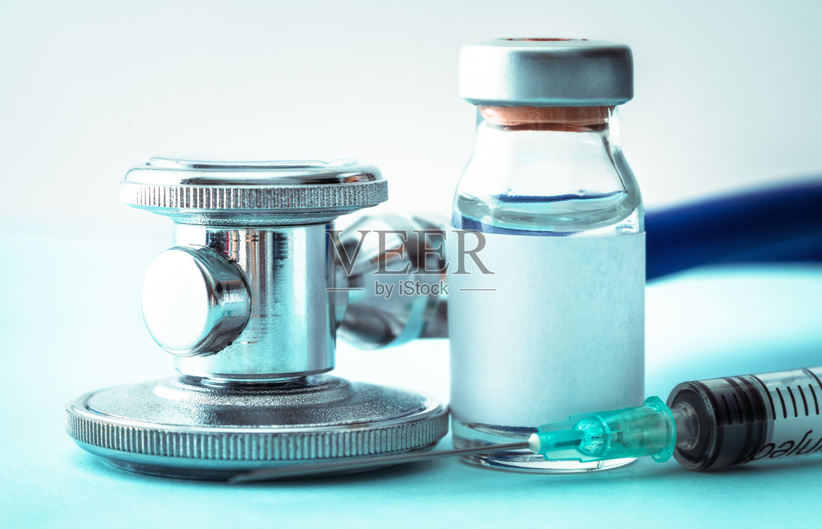 带注射器和听诊器的流感疫苗(蓝色背景)照片摄影图片