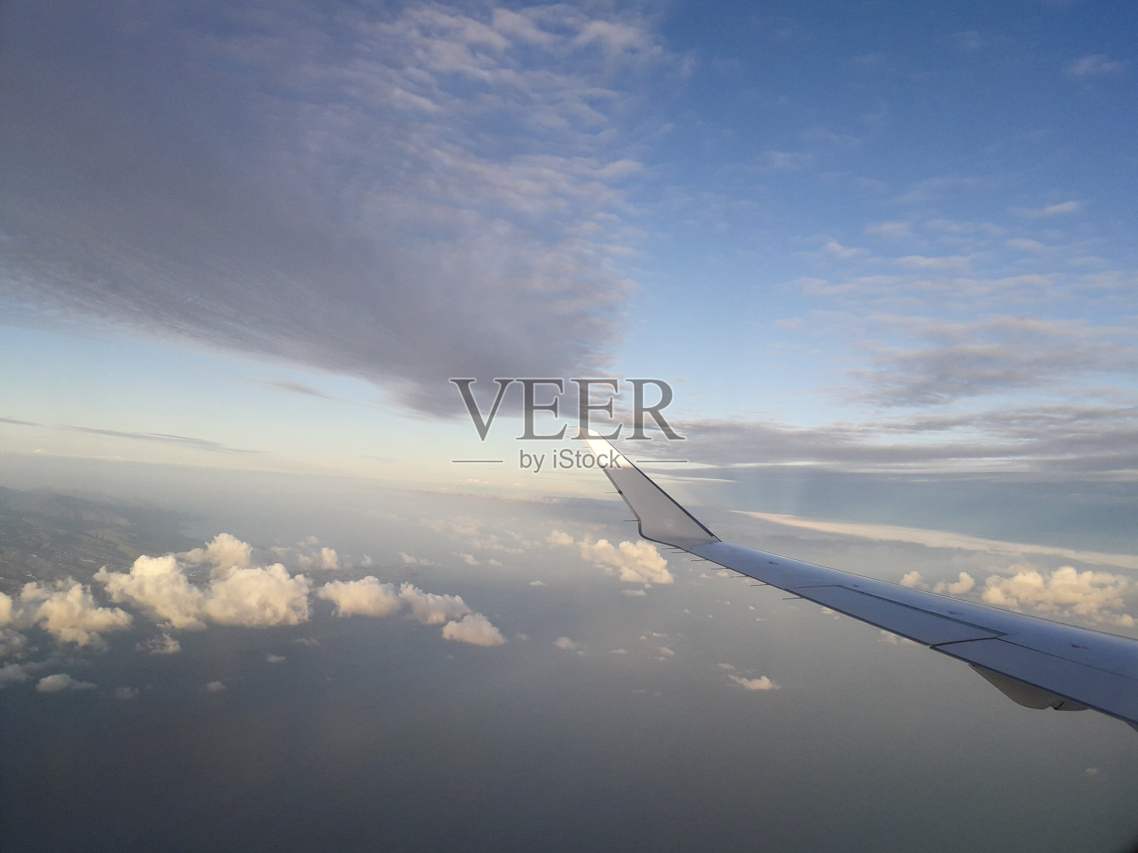 飞行和旅行，从飞机窗口看机翼上的蓝天和一些云照片摄影图片