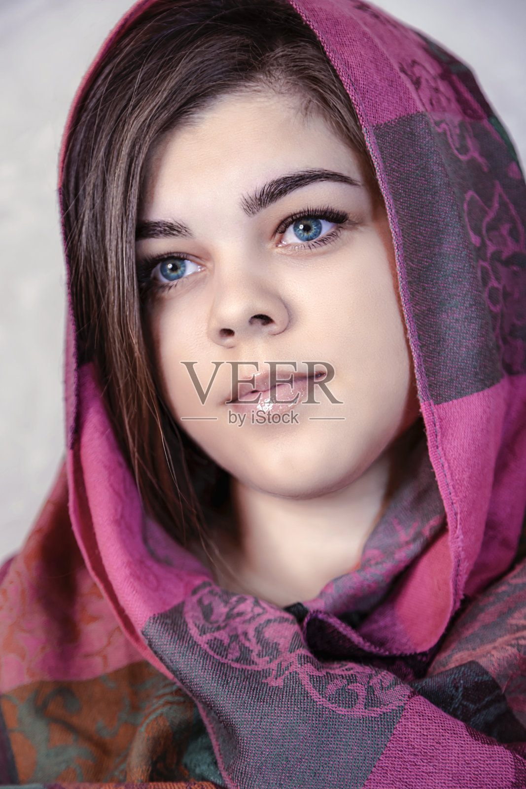 一个戴红围巾的小女孩的肖像。照片摄影图片