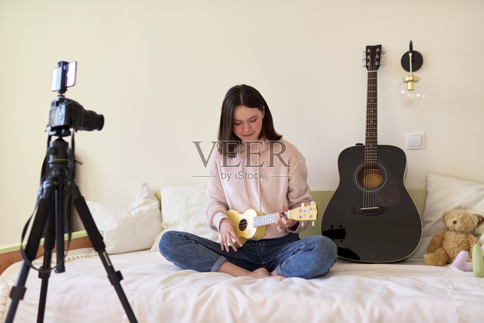 少女在弹奏尤克里里。博客，音乐频道，视频博客，照片摄影图片
