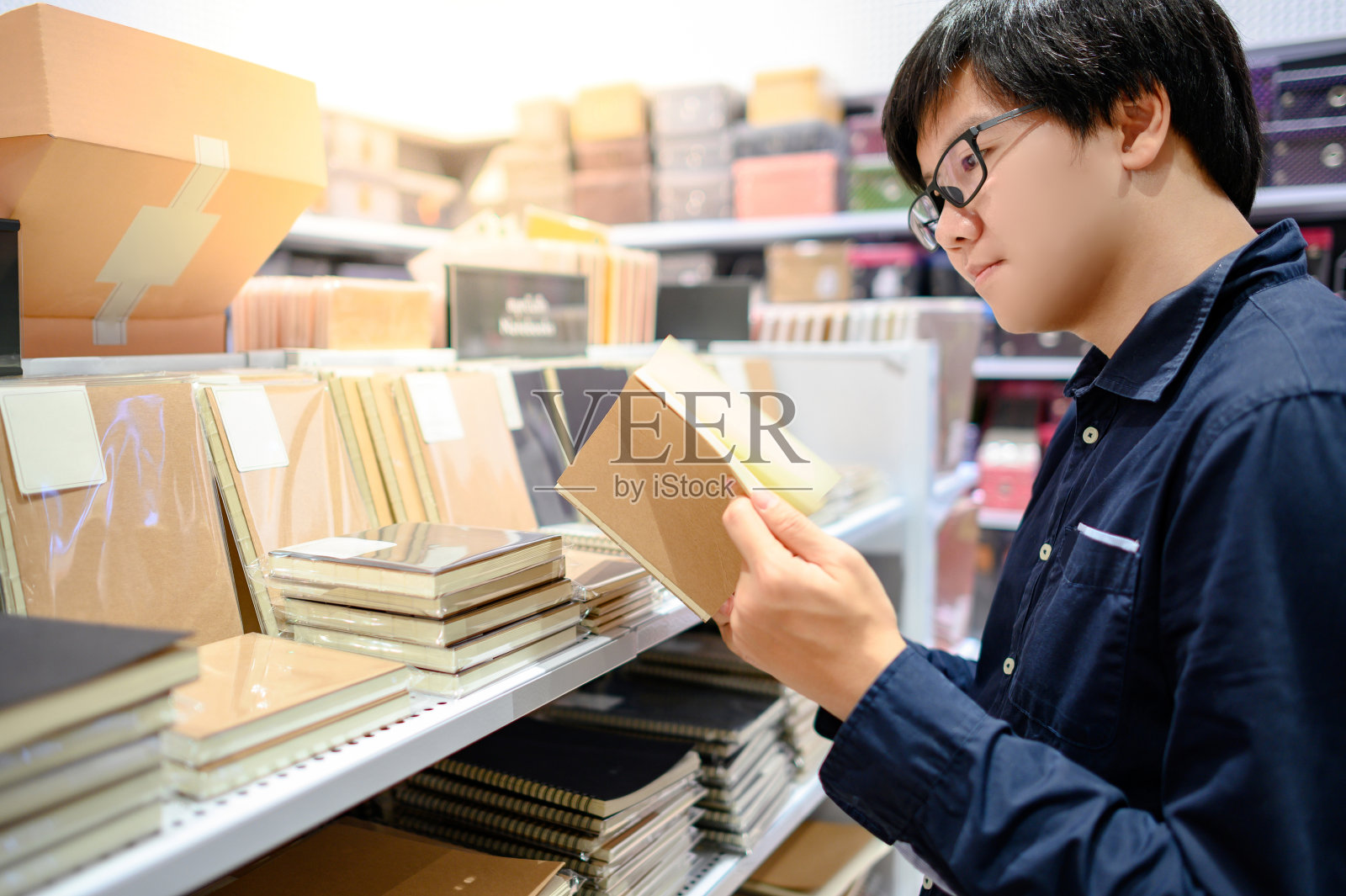 一名亚洲男子在文具店选购笔记本照片摄影图片