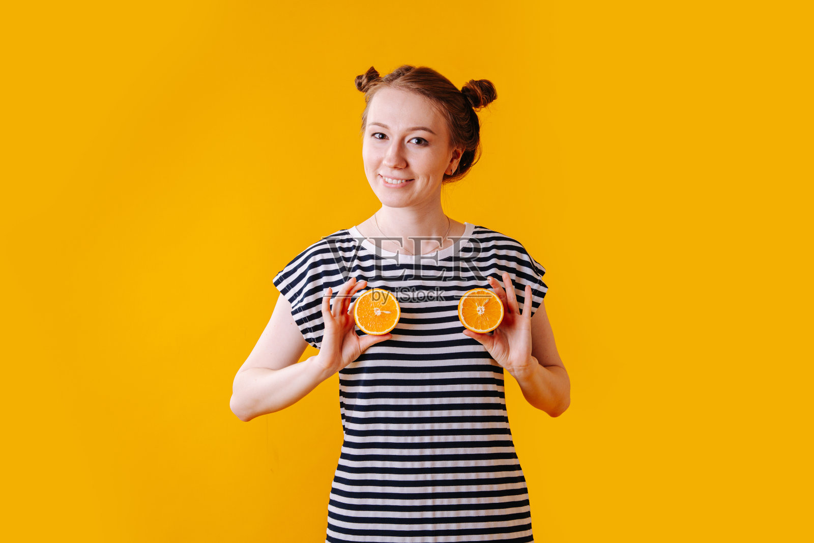 女孩用两半橙子画她的胸部照片摄影图片