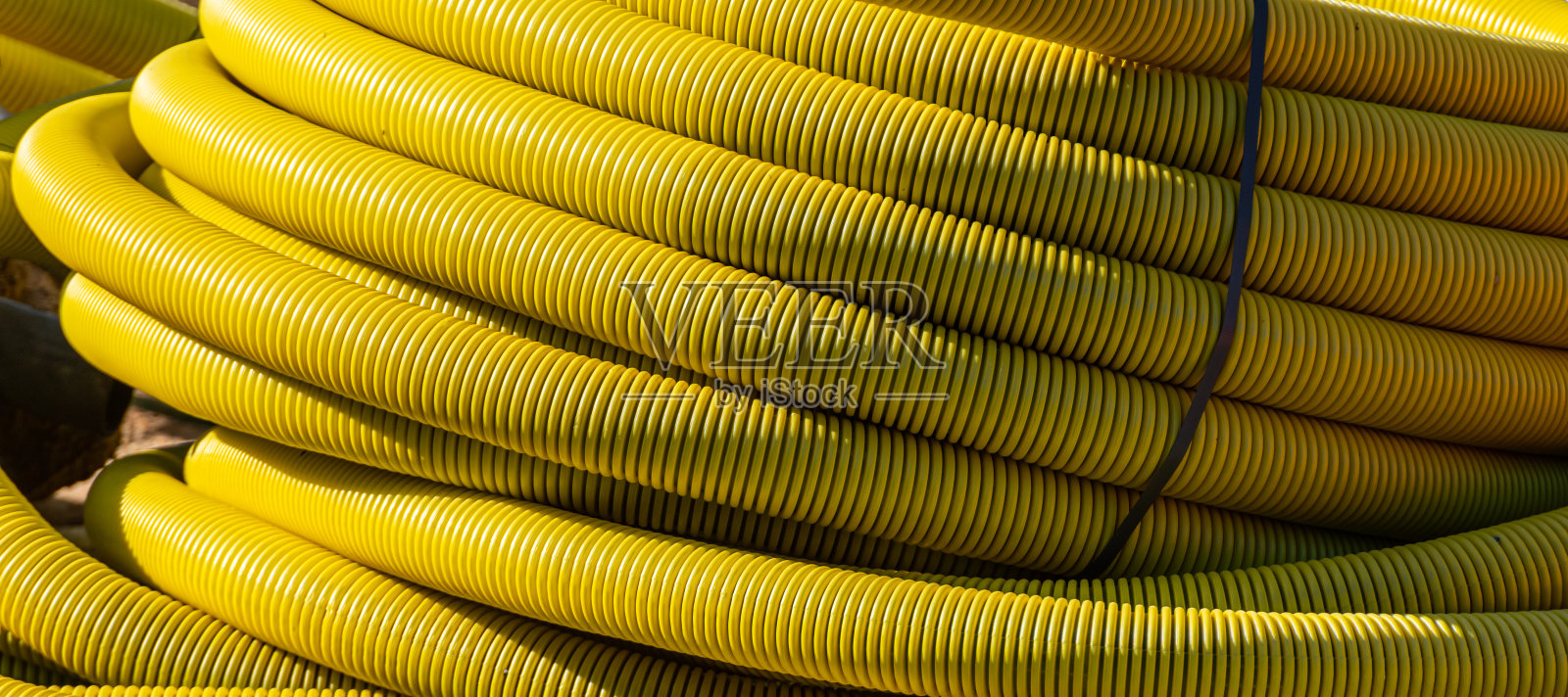 建筑工地上的一卷黄色软管照片摄影图片