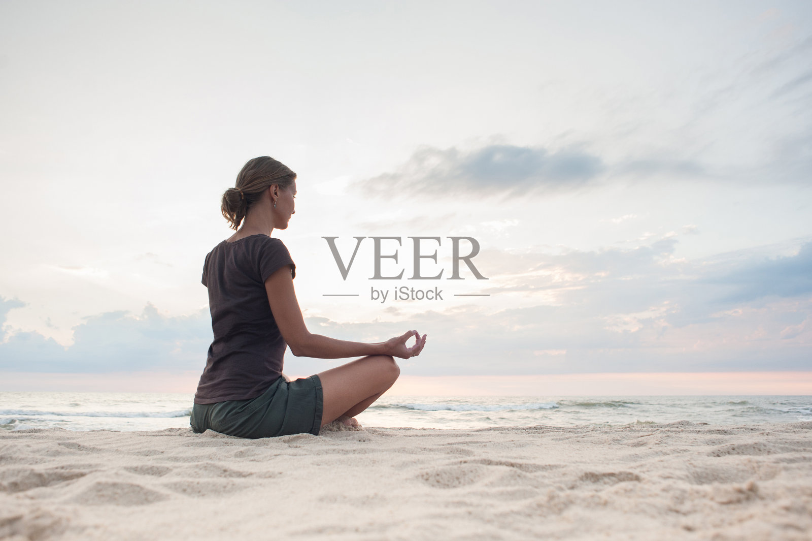 一个女人在日落时练习瑜伽。冥想与和谐理念照片摄影图片