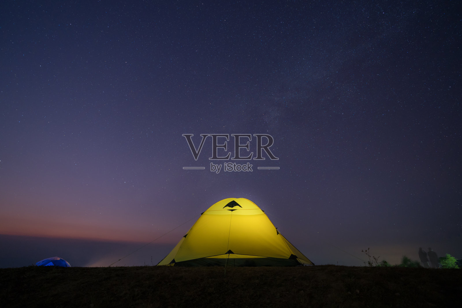 银河和星星的夜晚，晴朗的天空上方的山与露营帐篷位于泰国照片摄影图片