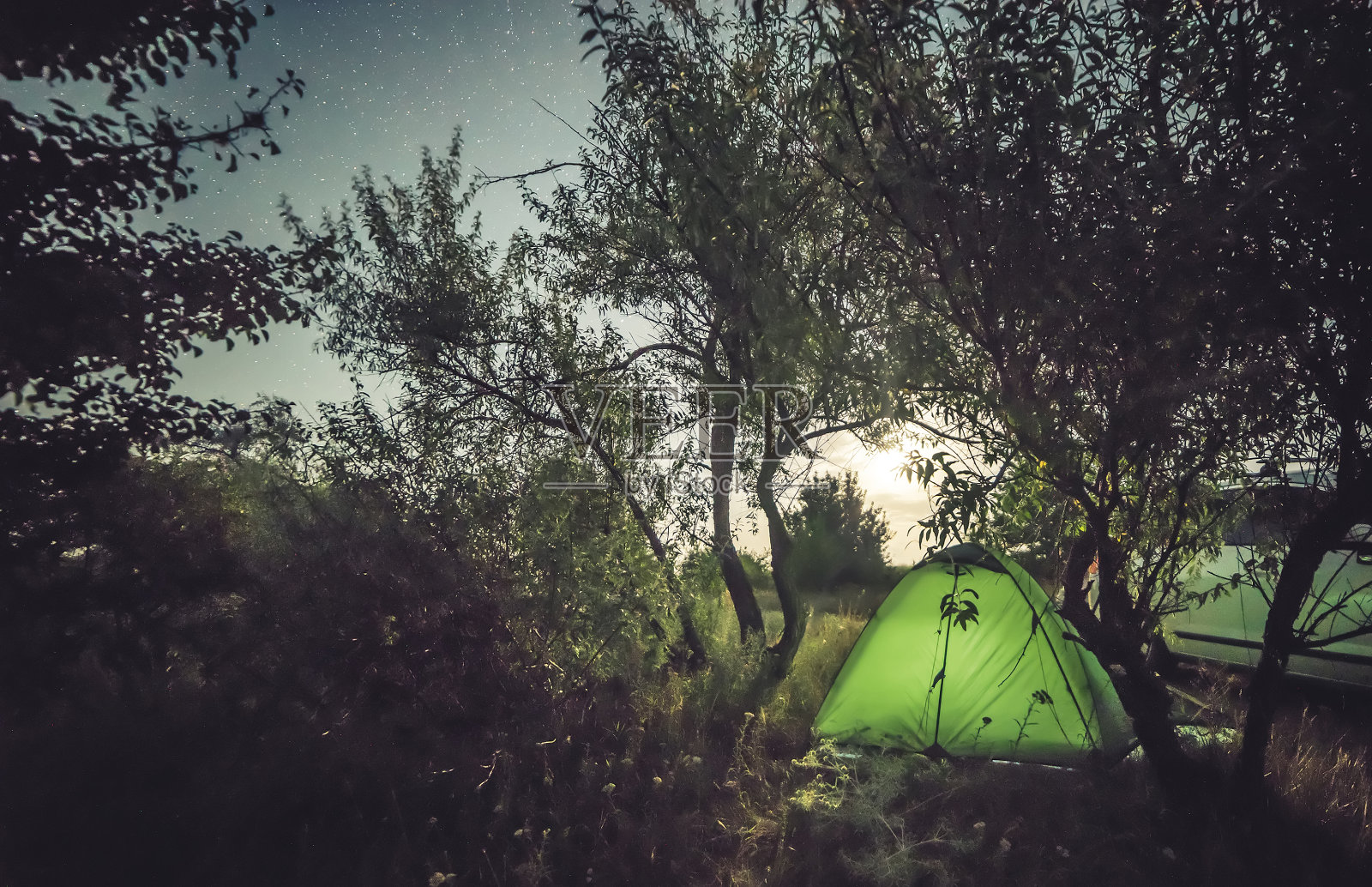 星光灿烂的夜晚，灯光微弱的帐篷照片摄影图片